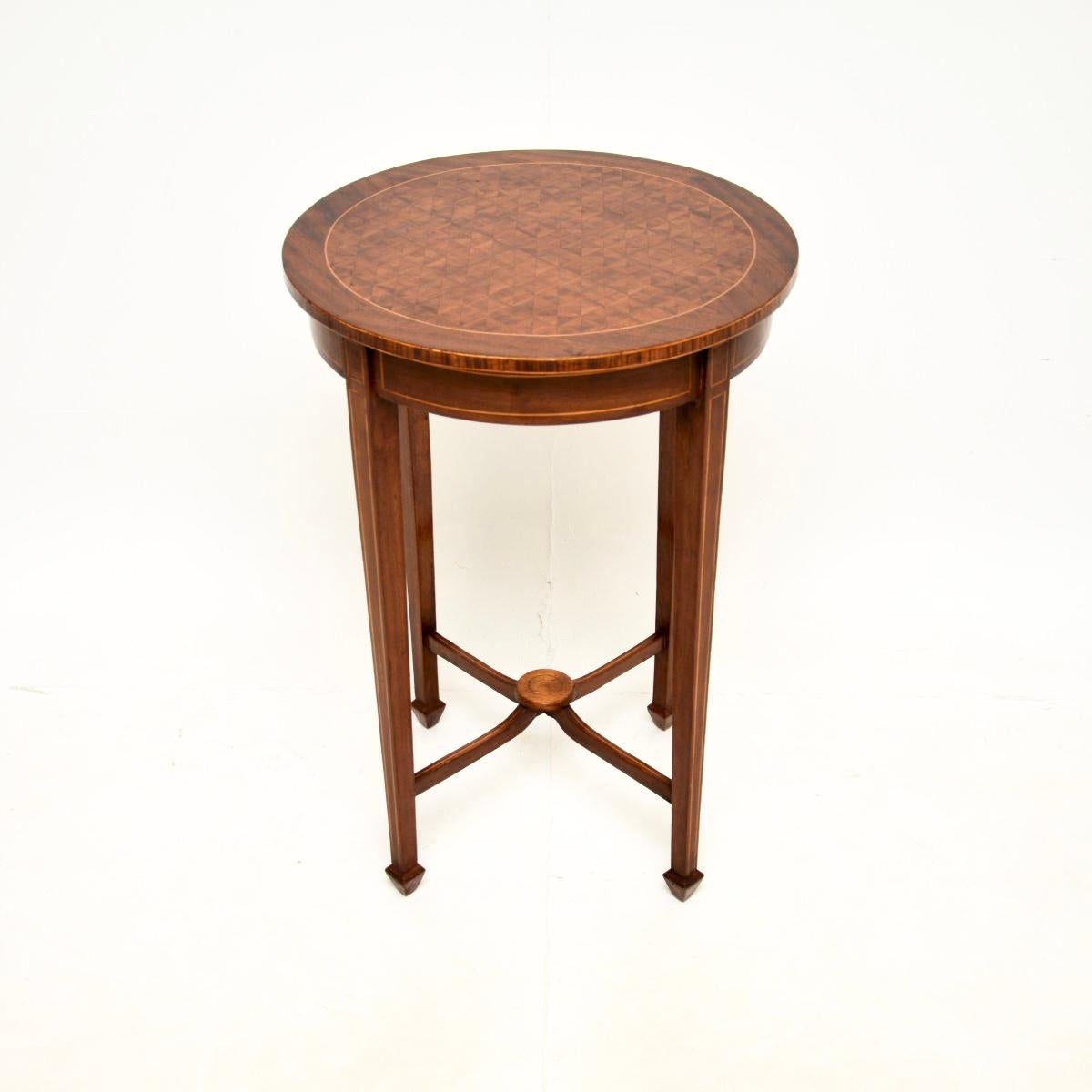Magnífica mesa auxiliar eduardiana antigua. Fabricado en Inglaterra, data aproximadamente del periodo 1900-1910.

Es de gran calidad, la parte superior circular tiene impresionantes diseños en el centro, con un borde incrustado de bandas de madera