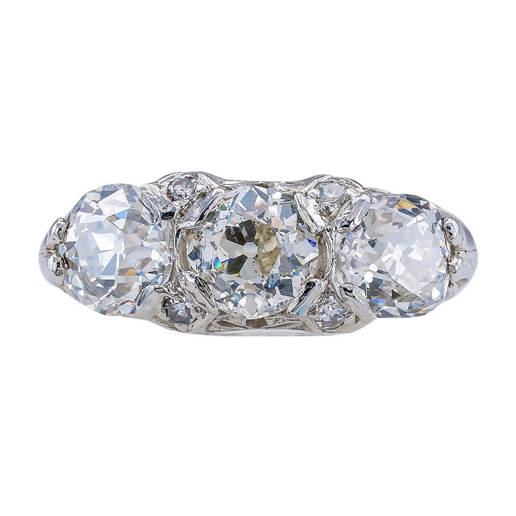 Edwardian three stone old Mine cut diamond totaling 2.50 carats antique filigree platinum ring circa 1910. In addition the the ring is set with four smaller single cut diamond totaling approximately 0.12 carat approximately H color SI clarity and