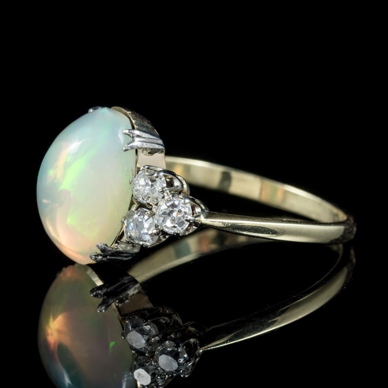 This fabulous antique Opal and Diamond ring is Edwardian, Circa 1910.

The ring displays a fabulous natural Opal in the centre which is over 5ct in size and complimented by six old cushion cut Diamonds at either side.

The lovely natural Opal is a