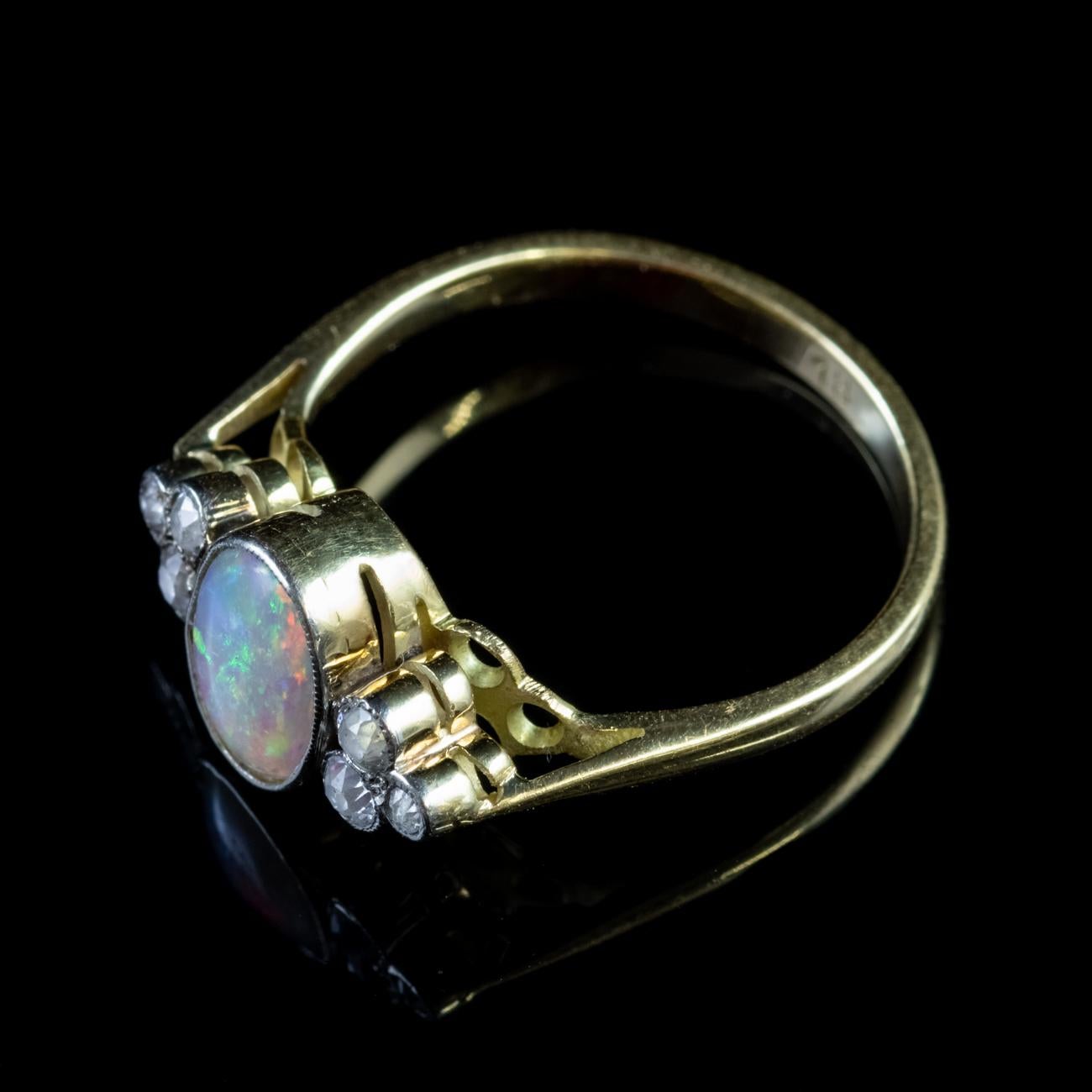 This beautiful Antique Edwardian ring is modelled in 18ct Yellow Gold and is set with a stunning central 1.65ct Natural Opal which is offset by three dazzling old cut Diamonds on either side. The Diamonds are miligrain set and weigh approx 0.08ct