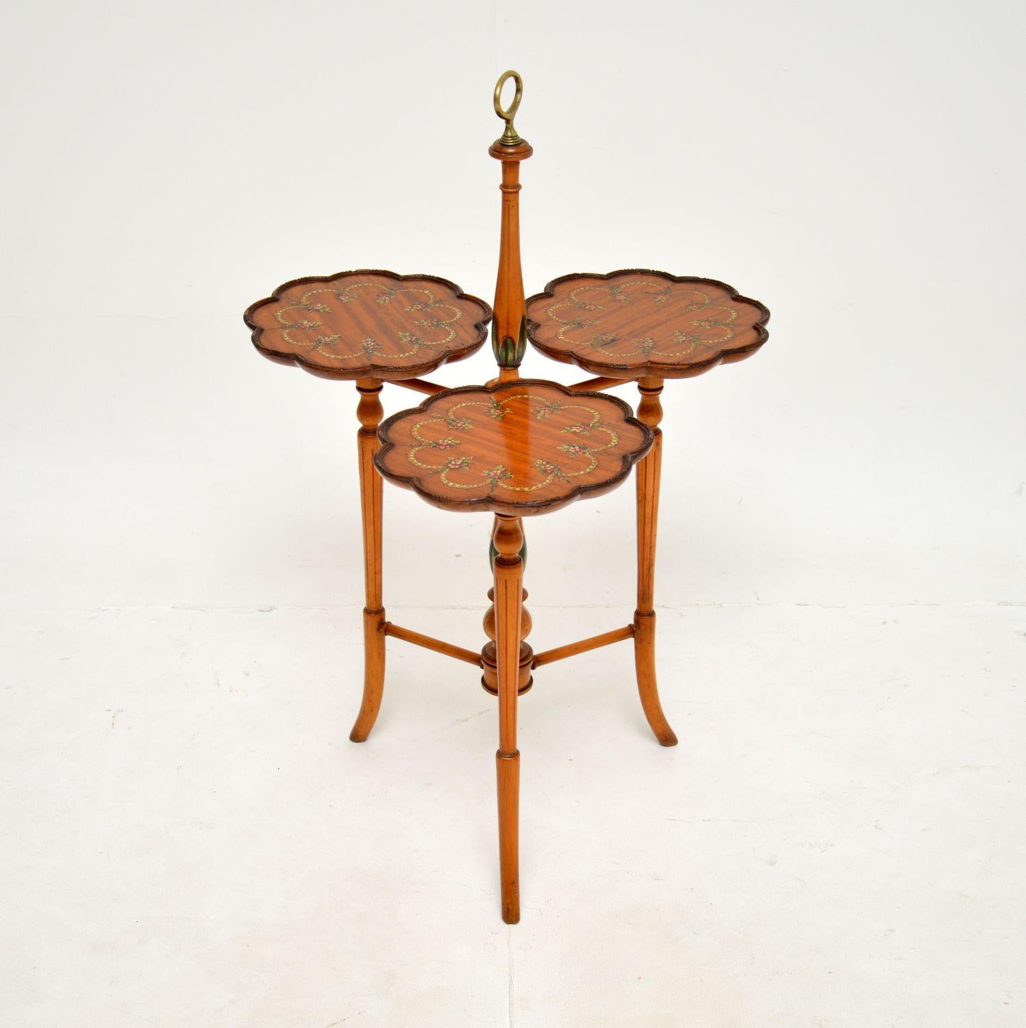 A beautiful and very decorative antique Edwardian painted satin wood cake stand / side table. This was made in England, it dates from around 1900-1910.

It has a gorgeous design, with a beautifully turned central column supporting three individual