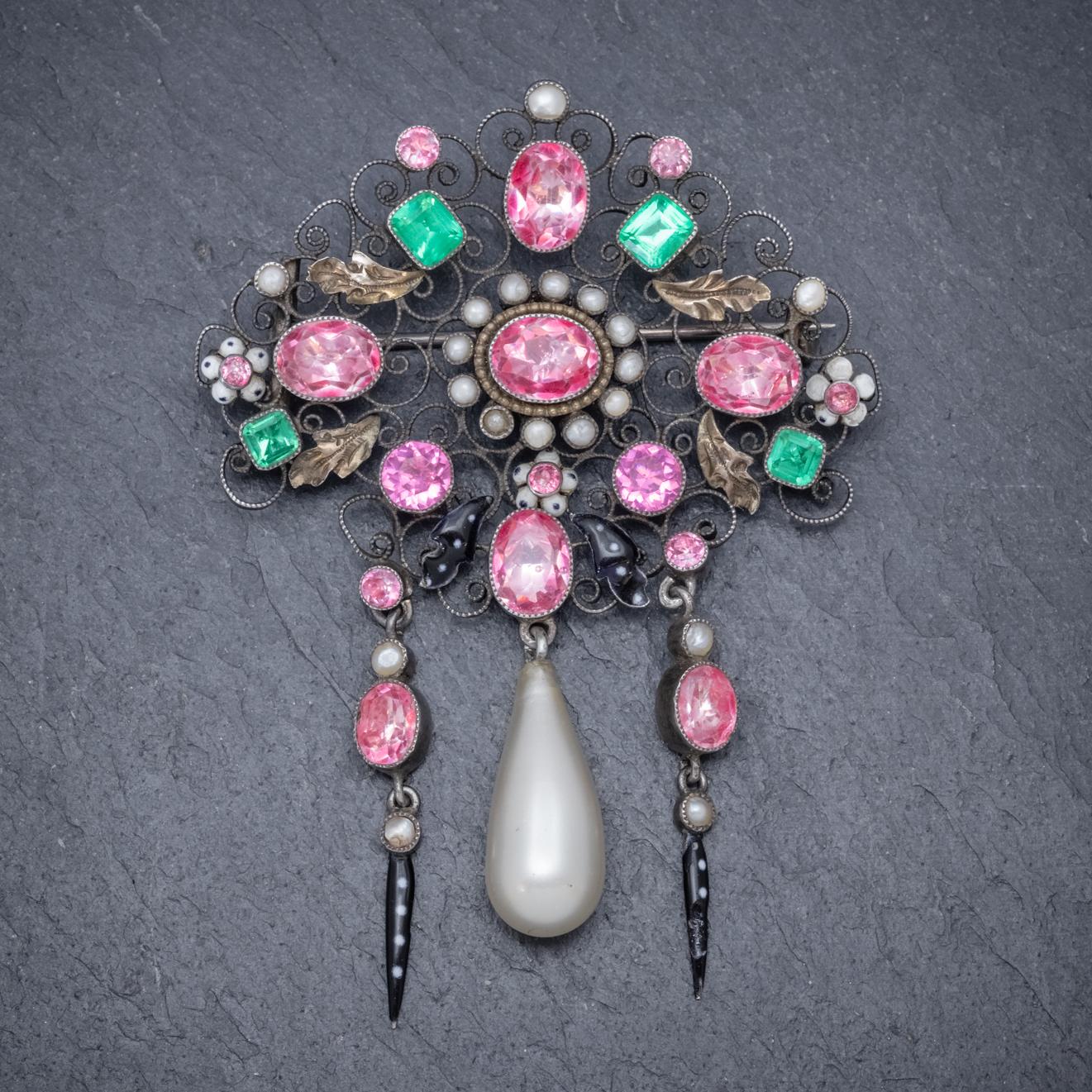 An exquisite antique Edwardian brooch decorated with pink and green Paste Stones and white Pearls which together represent the colours of the Suffragette movement which took place in the early 20th century. 

The stunning gallery has a beautiful