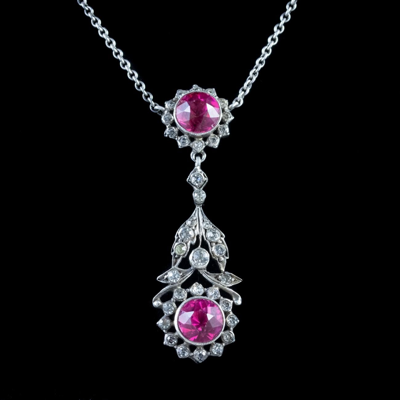 This beautiful Antique Edwardian pendant and necklace has been modelled in Silver, circa 1910. The pendant, which features a dropper, consists of a foliate style design set with two gorgeous pink Paste stones weighing approx. 1.75ct each. These are