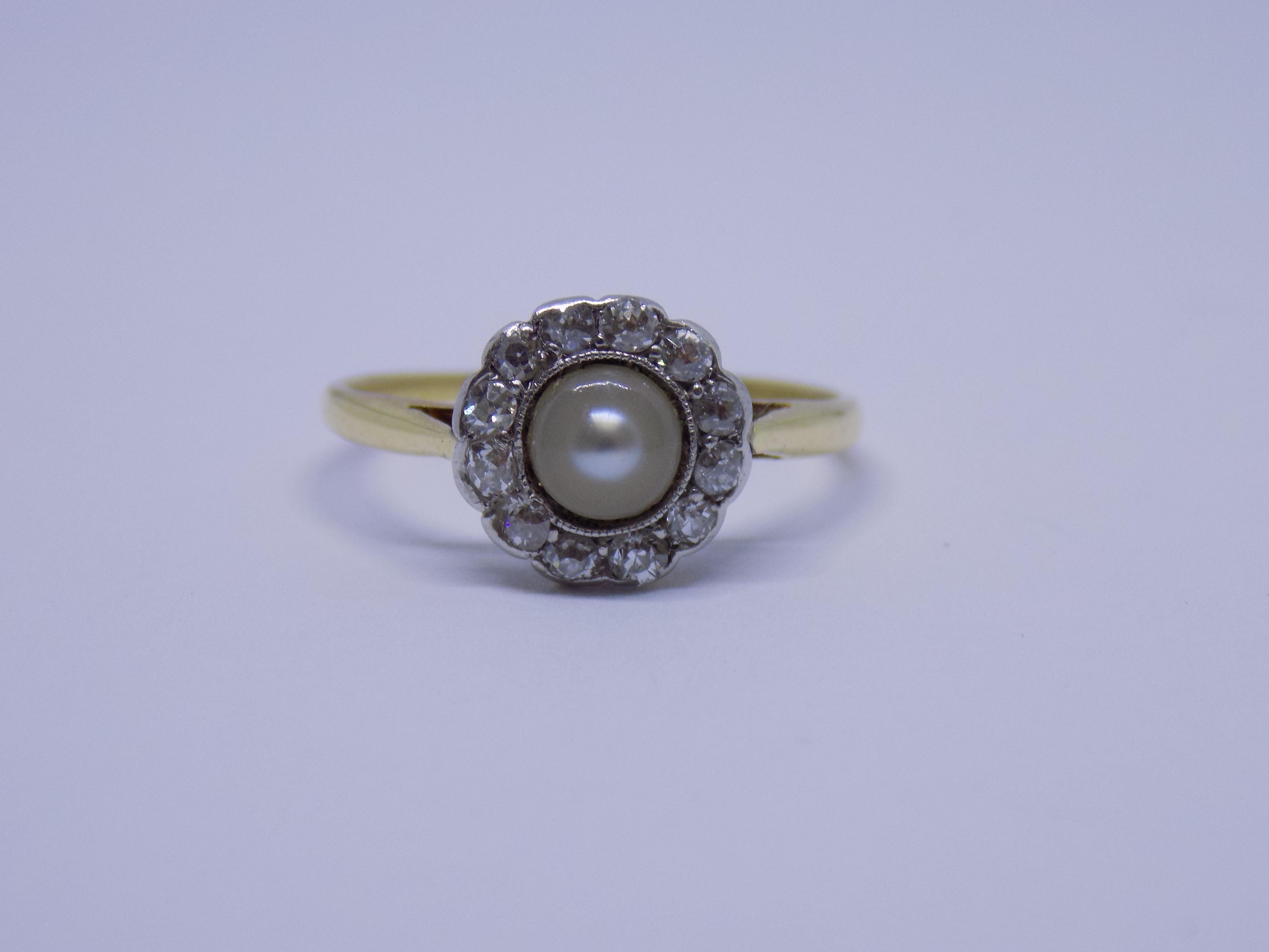 An Edwardian c.1910s timeless classic 18 Carat Gold, Platinum, Pearl and old European cut Diamond Halo ring. Diamonds mounted in Platinum setting. 
English origin.
Size K UK, 5.5 US  (sizable). 
Height of the face 9mm. 
Unmarked, tested 18 Carat