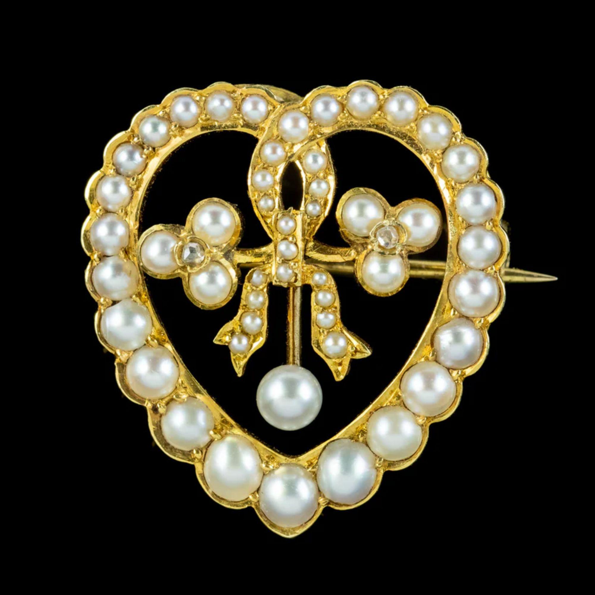 A pretty antique Edwardian brooch depicting a beautiful ribbon that loops into the shape of a heart and ties in a knot in the centre between two shamrocks. It’s lined with gleaming white pearls that graduate in size around the 15ct gold gallery with