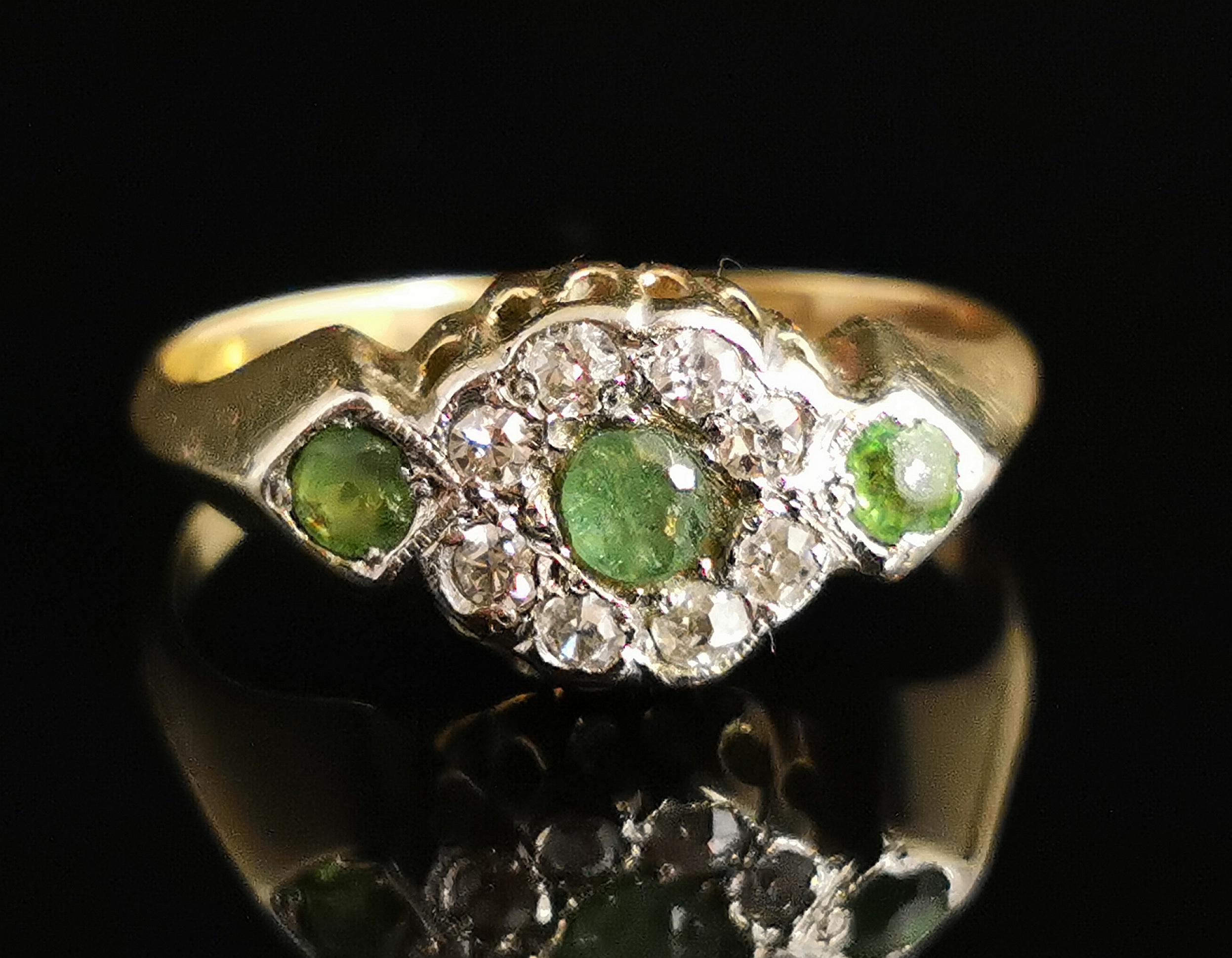 A stunning antique, Edwardian era Peridot and Diamond cluster ring in 18 karat yellow gold.

It has a nice chunky rich yellow gold band with slightly raised diamond shaped shoulders.

The centre features a single round cut peridot surrounded by a