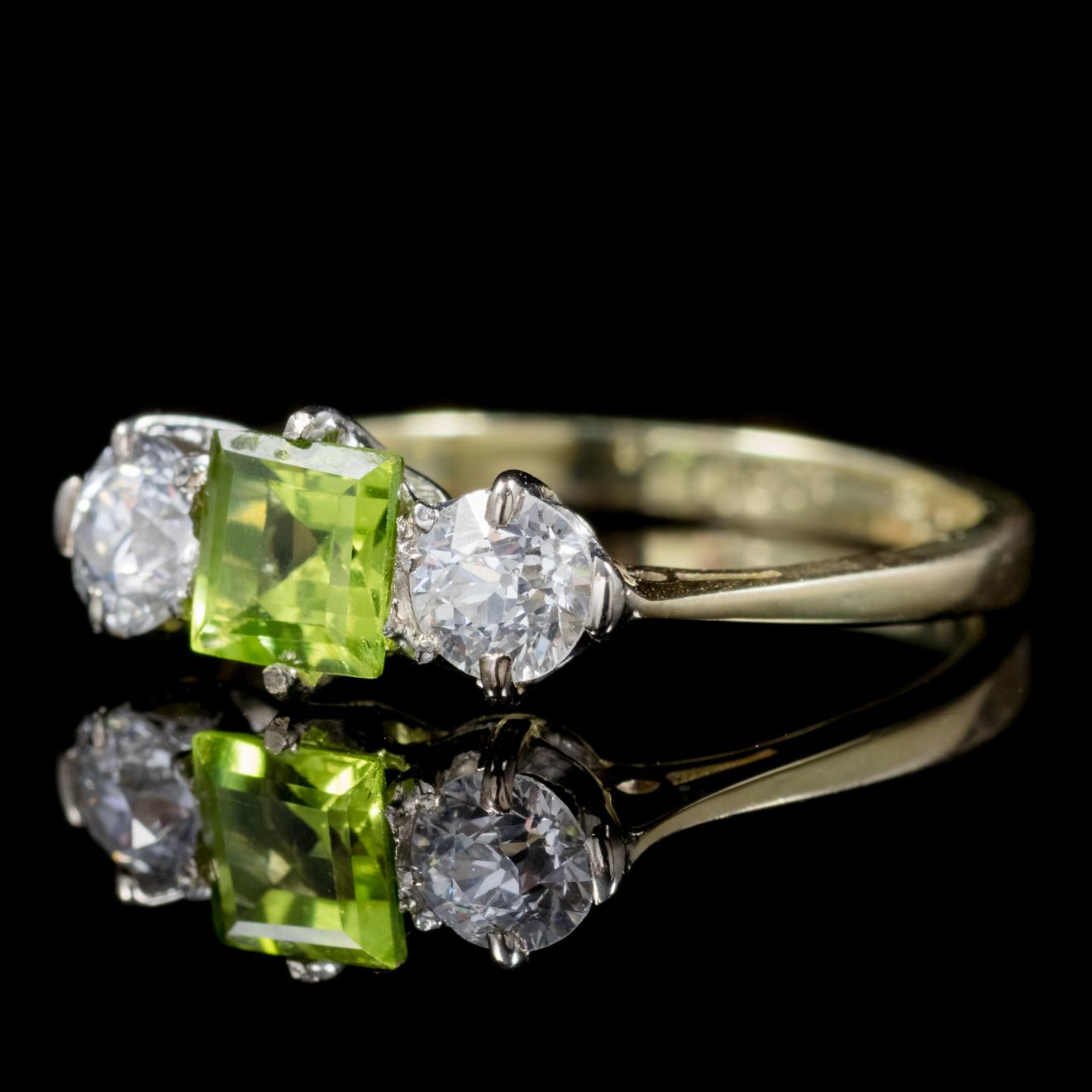A fabulous antique Edwardian trilogy ring C. 1915, adorned with a beautiful light green 0.60ct Princess cut Peridot flanked by two 0.15ct old cut Diamonds. 

The Peridot is a stone of lightness and beauty and was believed to be a stone of springtime