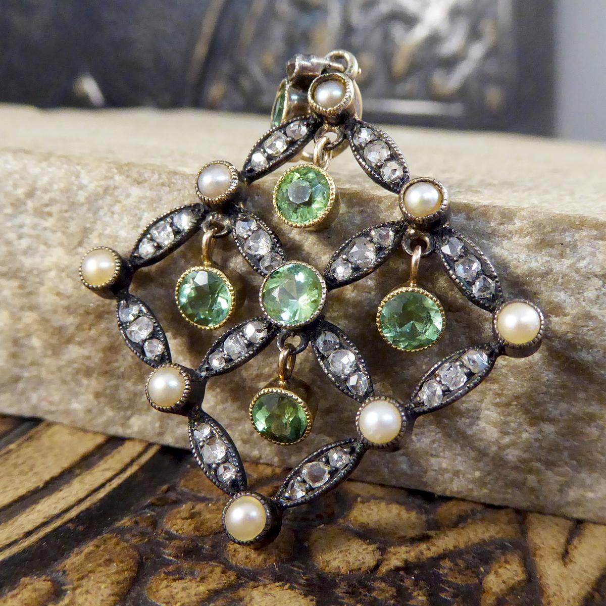A lovely hand crafted pendant, with a Yellow Gold back and Platinum setting bordering on Late Victorian and Early Edwardian. This gorgeous quality pendant holds six beautifully green Peridot stones in a millegrain rub over collar setting, four of