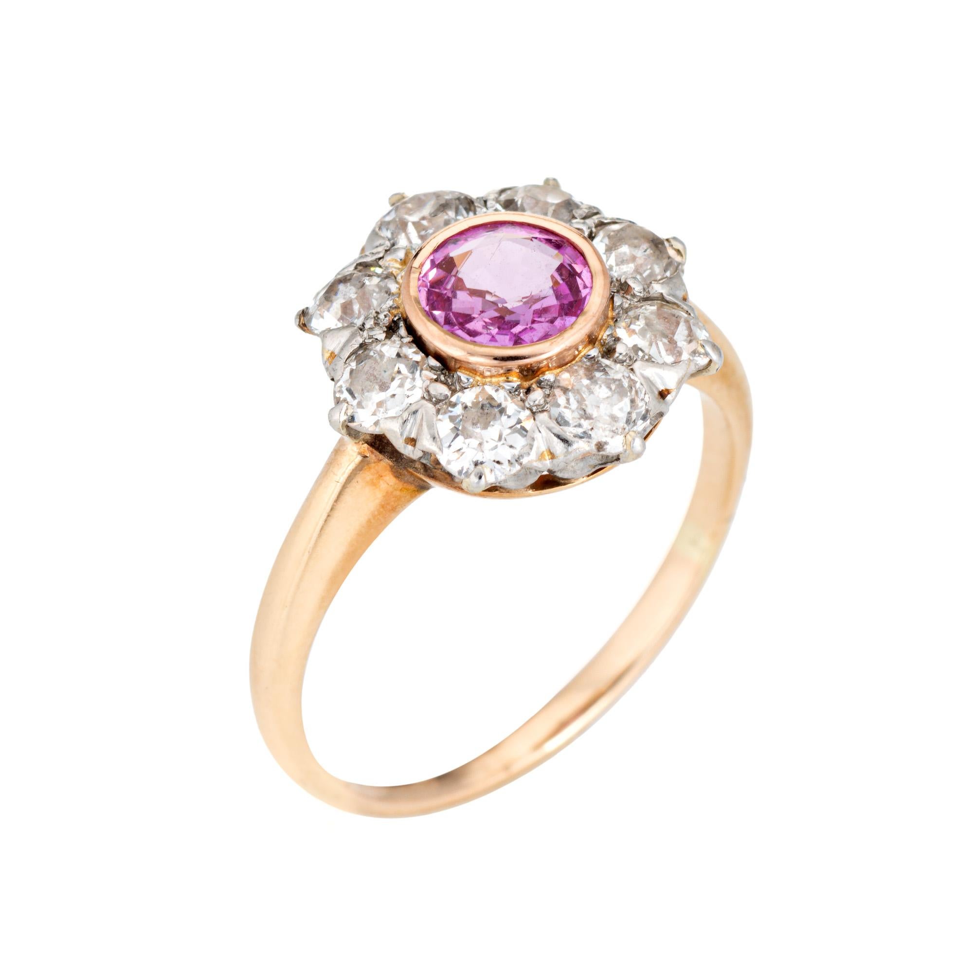 Stylish antique Edwardian pink sapphire & diamond cluster ring crafted in 14k yellow gold (circa 1900s to 1910s).
One center set pink sapphire is estimated at 0.50 carats, accented with eight estimated 0.15 carat old mine cut diamonds. The total