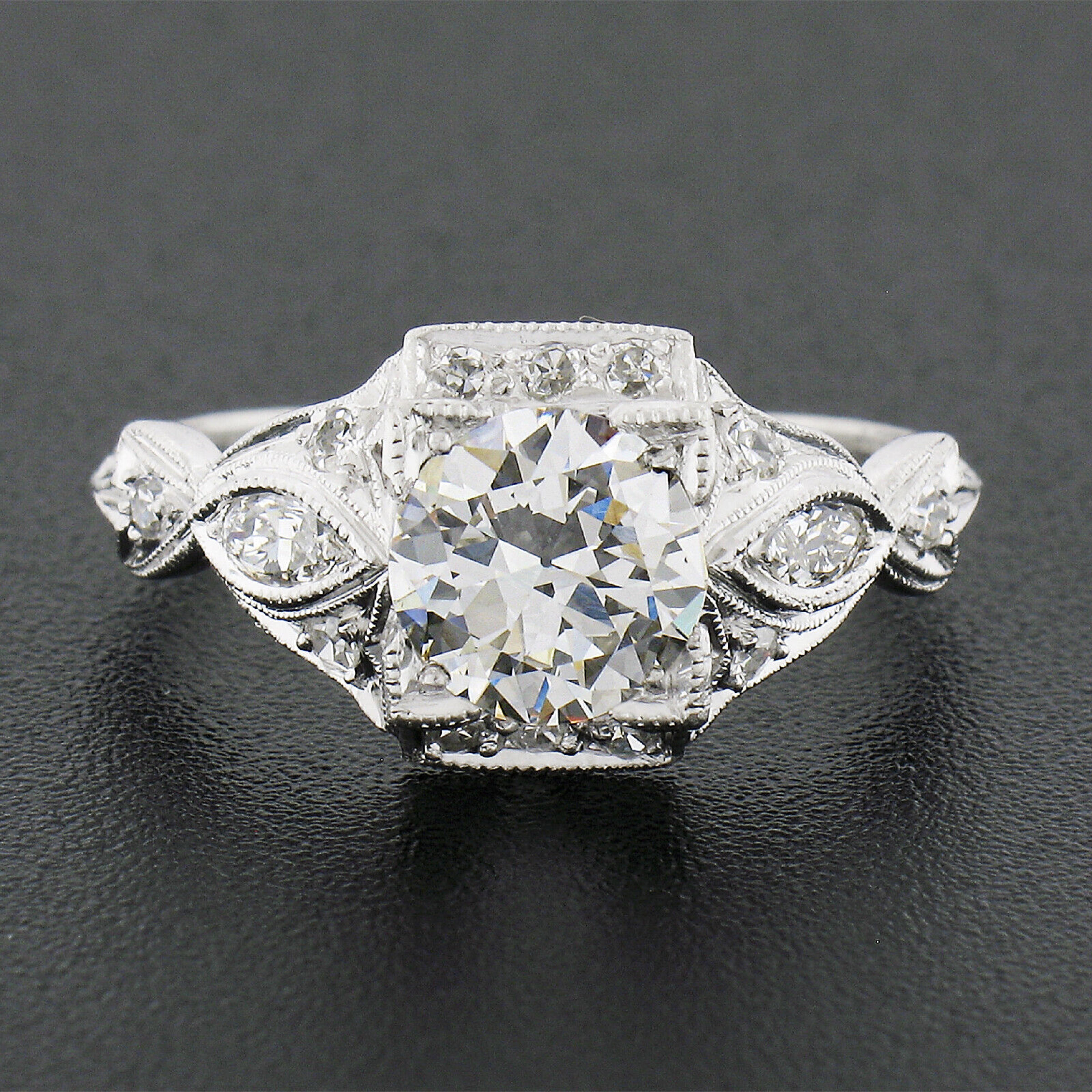 This is an absolutely breathtaking, highly detailed, antique engagement ring that was crafted from solid platinum during the Edwardian/Art Deco period. It features a GIA certified old European cut diamond neatly set at the center and elegantly held
