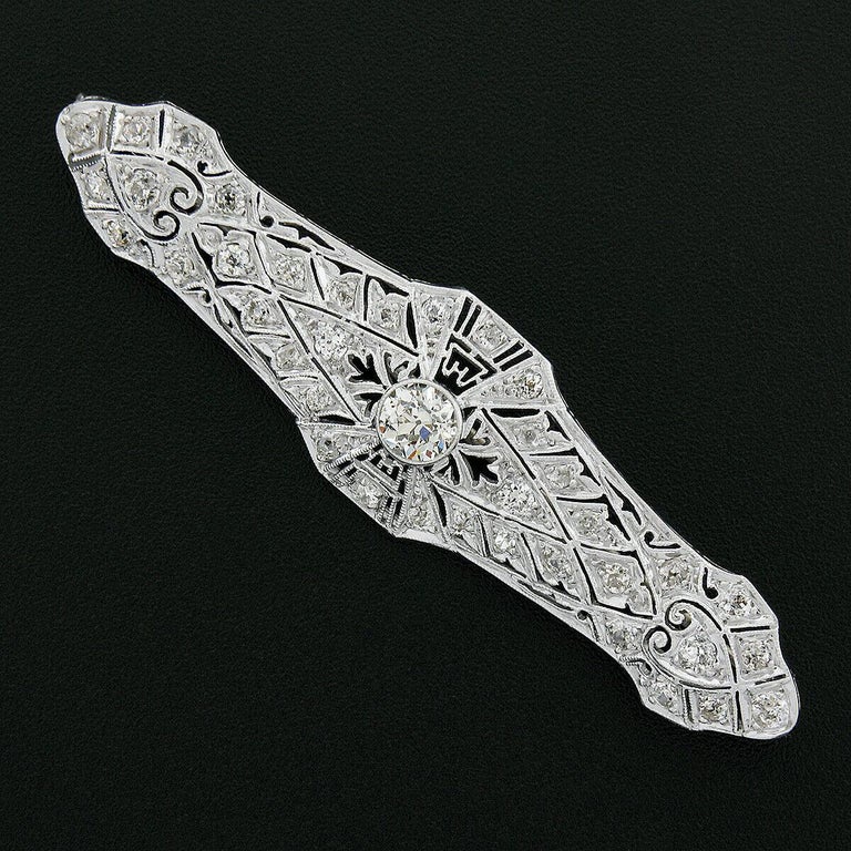 Here we an absolutely breathtaking antique bar pin brooch that was crafted from solid platinum during the Edwardian era. It features a truly elegant open work design that is completely completely drenched with fine quality, old cut, diamonds