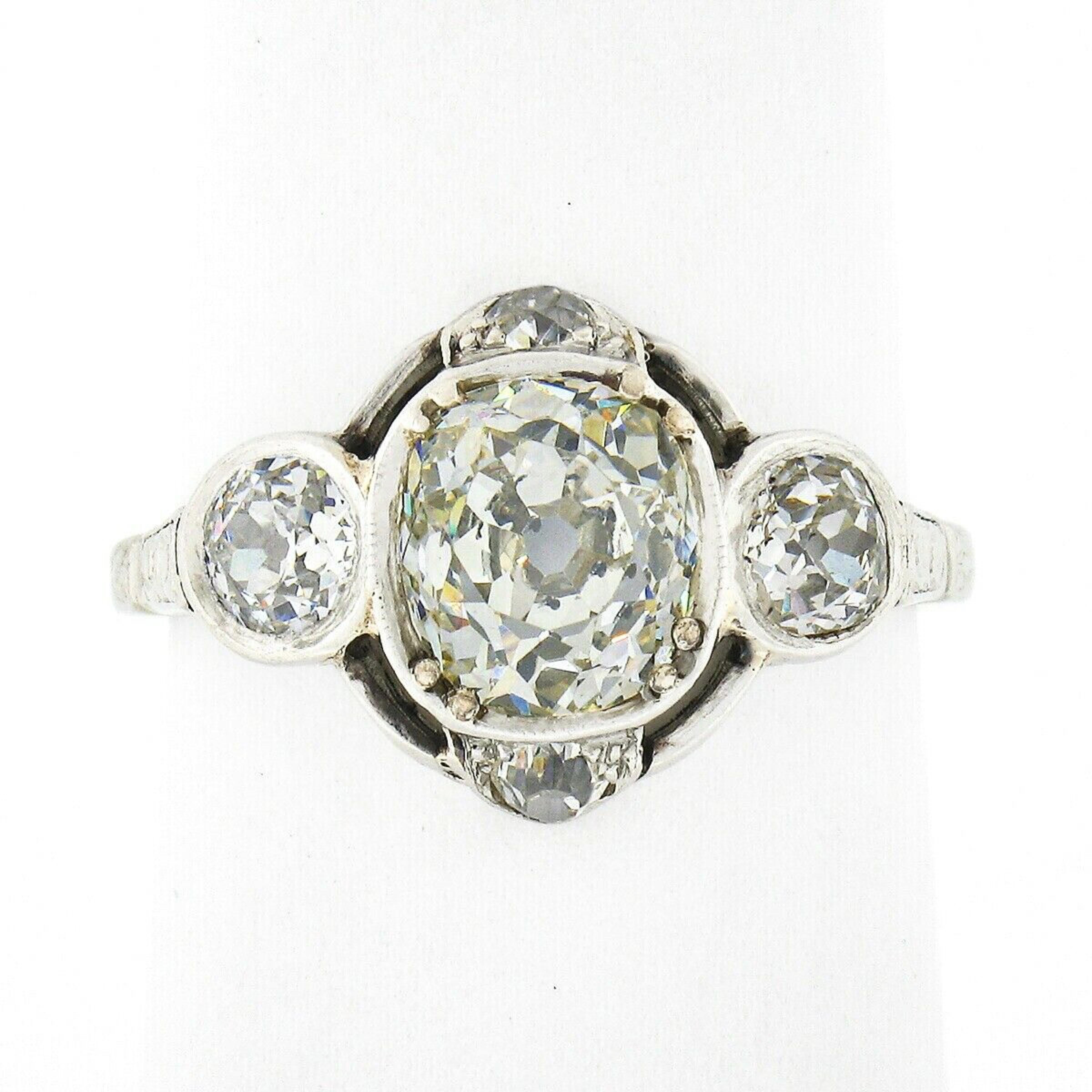 This breathtaking antique diamond engagement ring was crafted from solid platinum during the Edwardian era and features a stunning old mine cut diamond solitaire neatly set at the open center. This gorgeous diamond shows a nice large size with