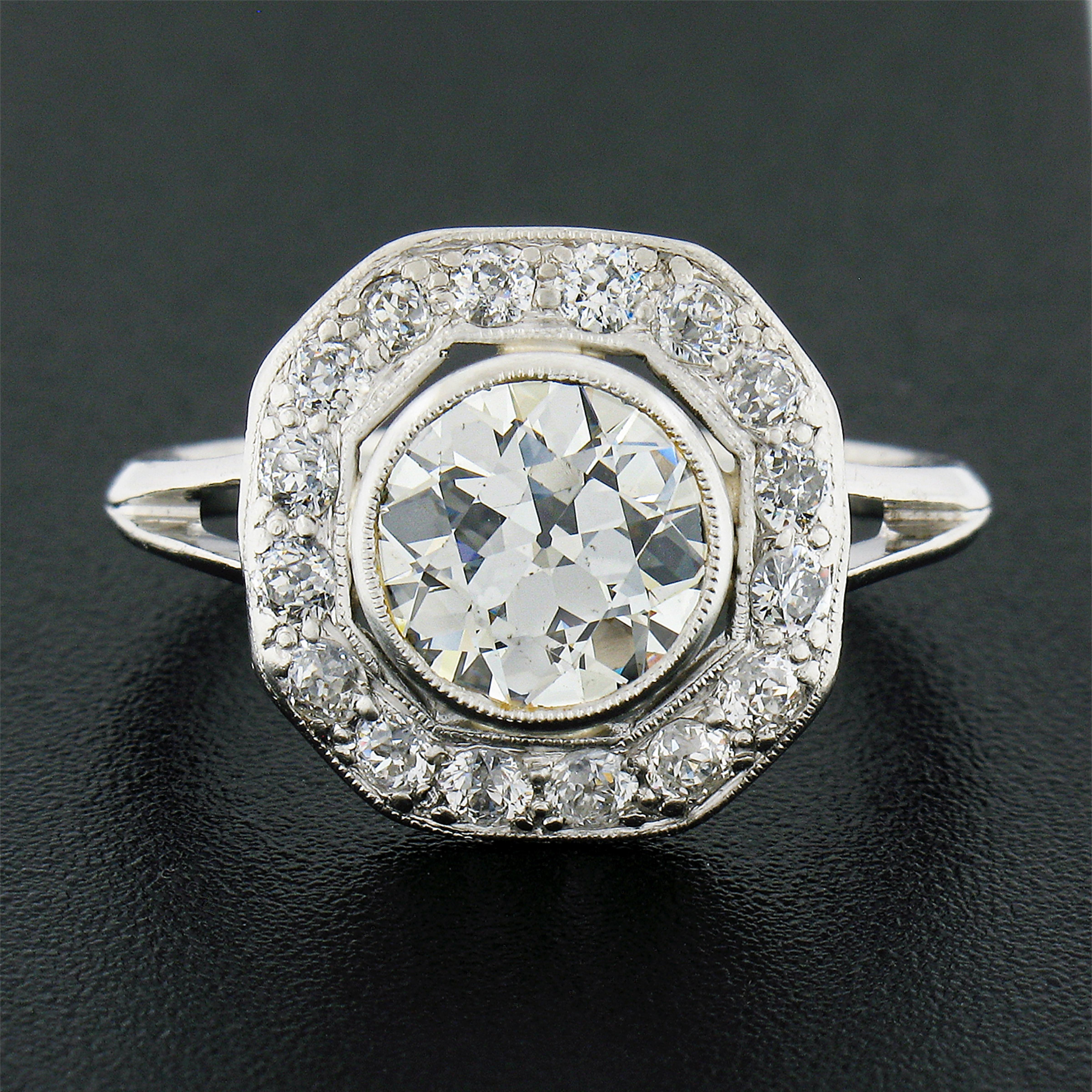 This is an absolutely jaw dropping antique platter ring crafted in solid platinum during the Edwardian period. It features a large and breathtaking old European diamond solitaire neatly bezel set with milgrain at the center, and further surrounded