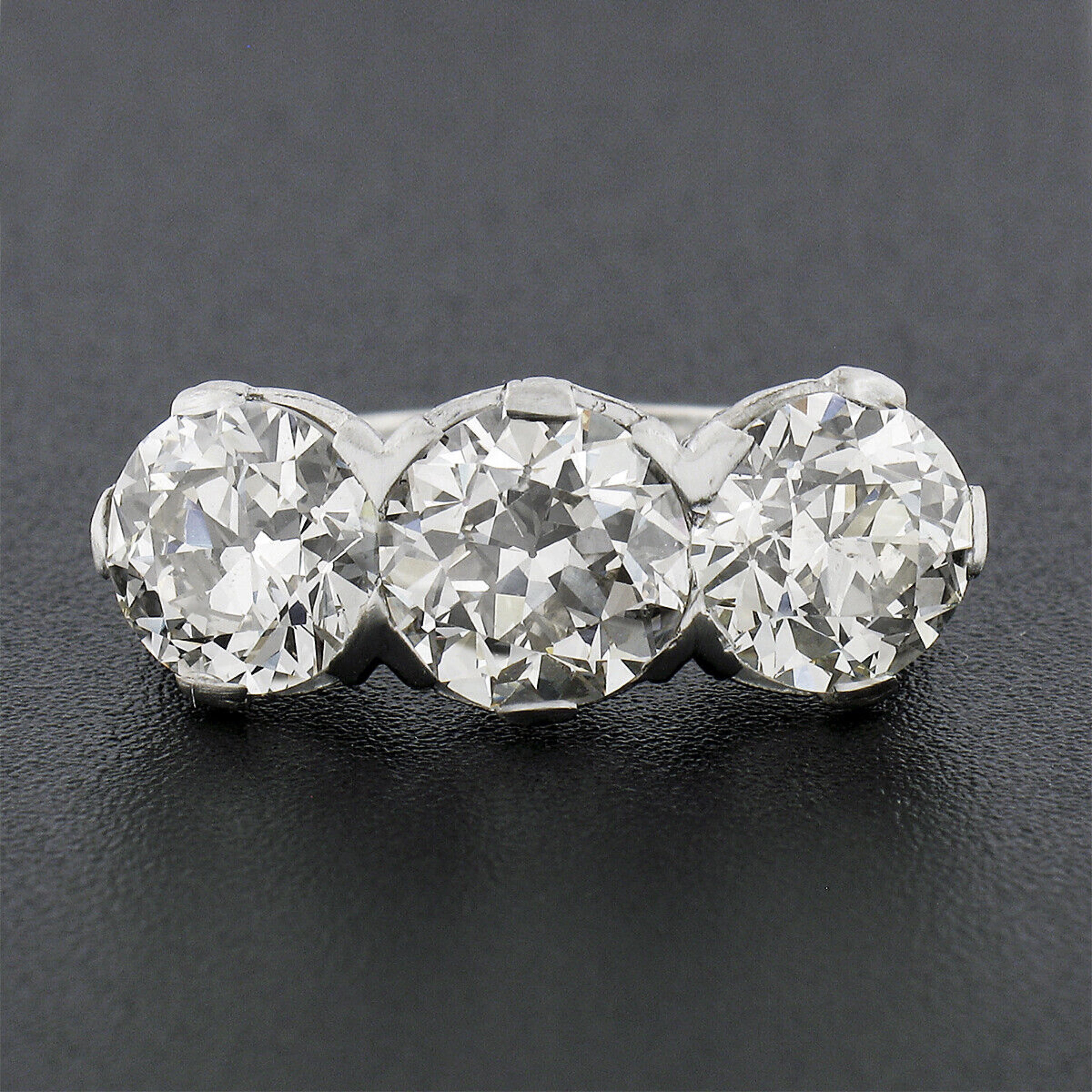 You are looking at a breathtaking and truly jaw dropping antique diamond three stone ring that was crafted from solid platinum during the Edwardian period. All three of these large old European cut diamonds have been certified by GIA and total an