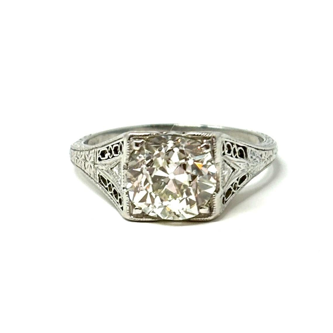 A wonderful antique diamond ring set with an old European cut diamond weighing approximately 1.75 carats set in a pierced and engraved platinum mounting. This is a perfect engagement ring for anyone who admires elegant Edwardian style