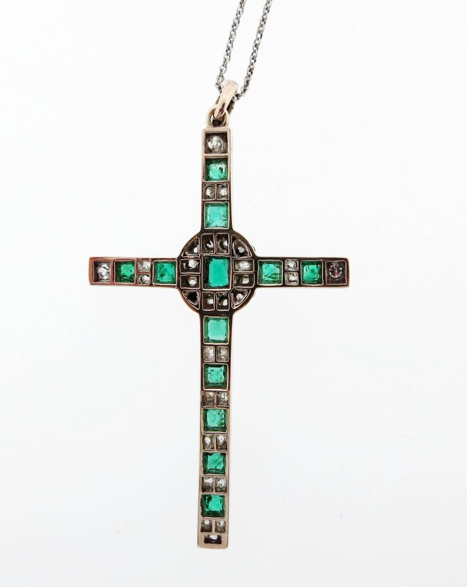 Edwardian platinum top and gold back emerald and diamond cross circa 1900. The cross measures 2.25 inches in length. Set with 12 faceted natural emeralds totaling approx  1.8cts. and 34 old cushion and mine cut diamonds totaling approx. 1.0cts. The