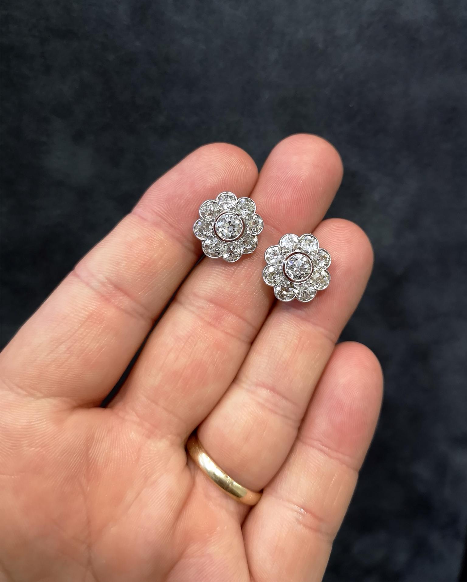 Exceptional Edwardian earrings in platinum. Sparkling old-cut diamonds mounted in bezel settings with exquisite millegrain detailing. Hook style fittings. Approximately 5.00 carats in total, H-I colour and SI clarity. 6g. 15mm x 15mm x 5mm.