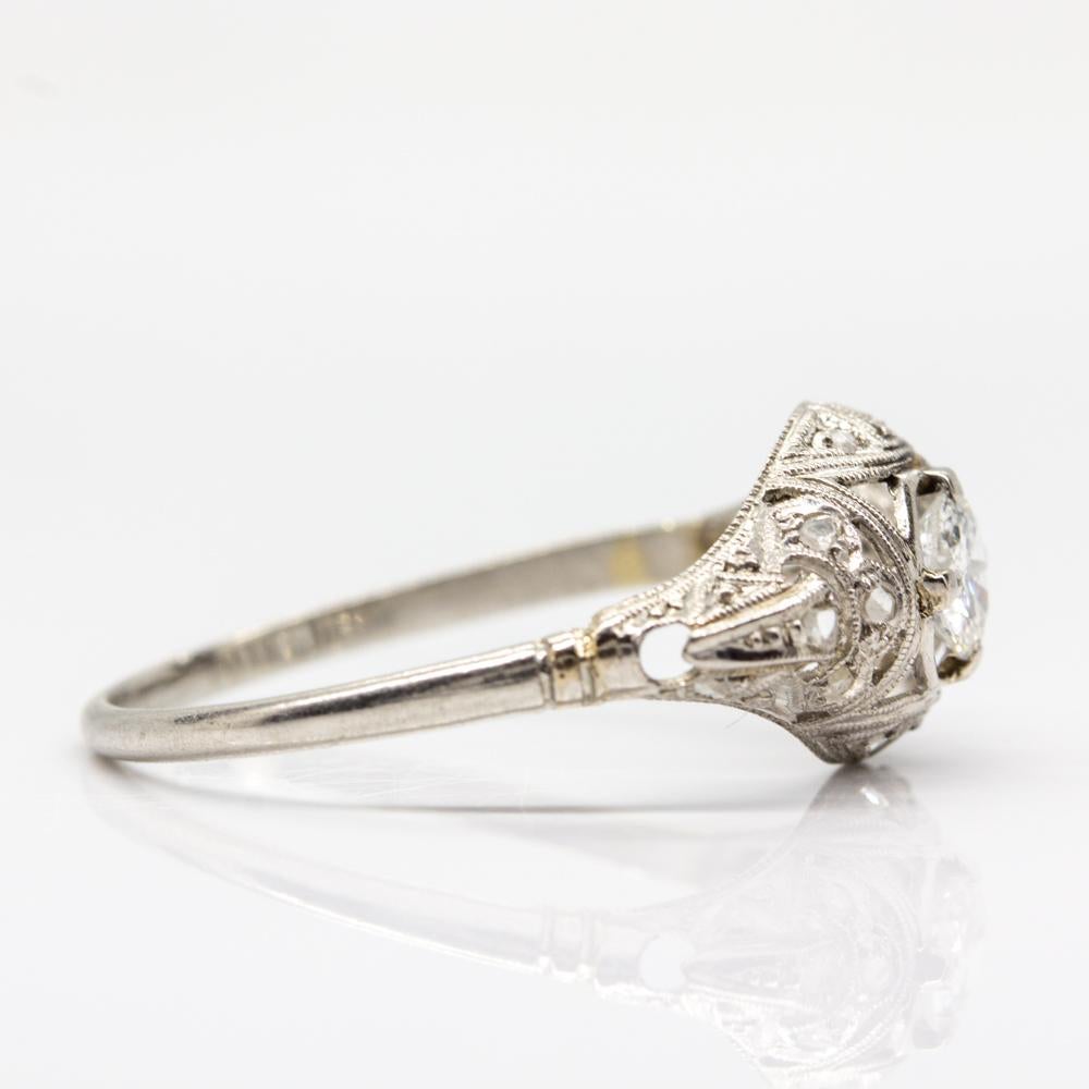 Period: Edwardian (1901-1920)
Composition: Platinum
•	1 old mine cut diamond of I-SI3 0.30ctw.
•	12 rose cut diamonds I-SI1 0.15ctw
Ring size: 7 ½ 
Ring face measurement: 9mm by 18mm
Height: 4mm
Total weight: 2.0 grams – 1.3dwt
