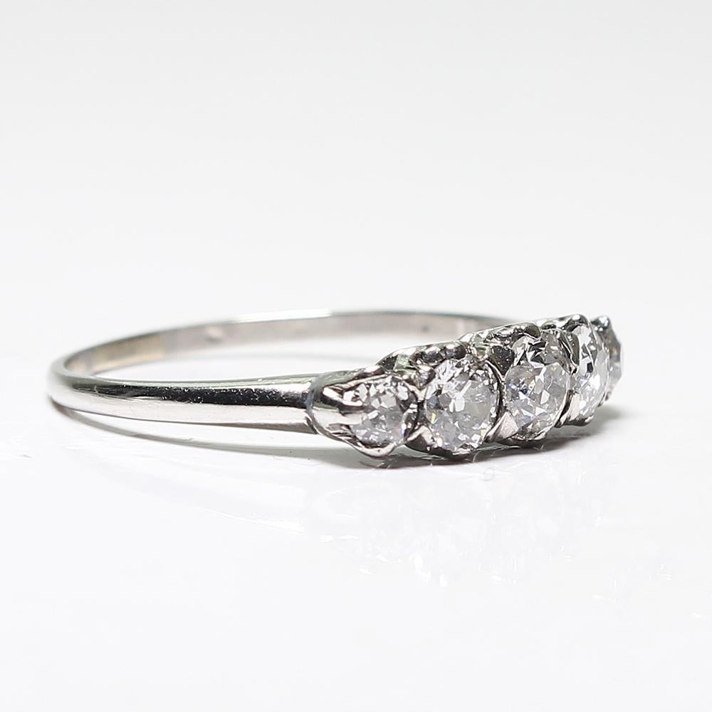 Period: Edwardian (1901-1920)
Composition: Platinum.

Stones:
•	1 Old mine cut diamond of G-SI1 quality that weighs 0.25ctw.
•	4 Old mine cut diamonds of G-VS2 quality that weighs 0.60ctw.
Ring size: 6 ¼    
Ring face:  15mm by 4mm. 
Rise above