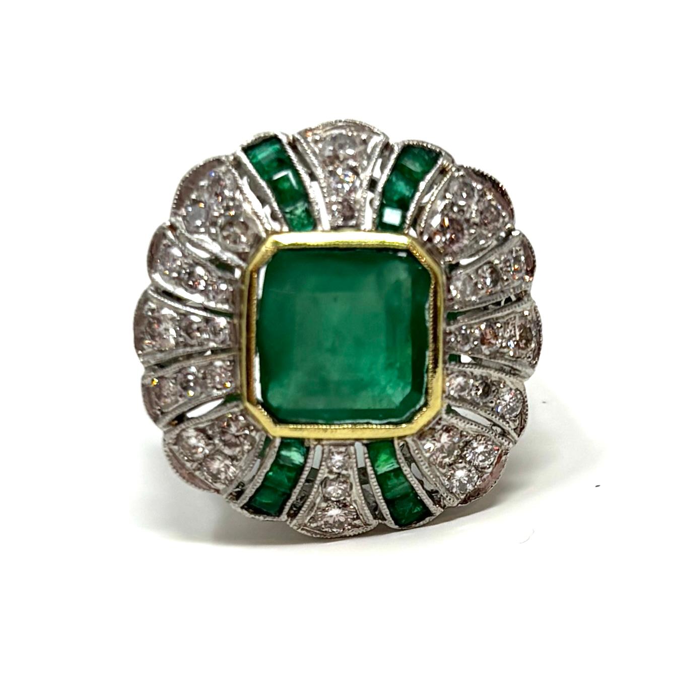 A lovely Art Deco style emerald and diamond cocktail ring made in the mid 20th century. This is the classic emerald green that is the color of the moment!

It contains approximately 3.73 carats total weight emeralds and approximately 1.07 carats