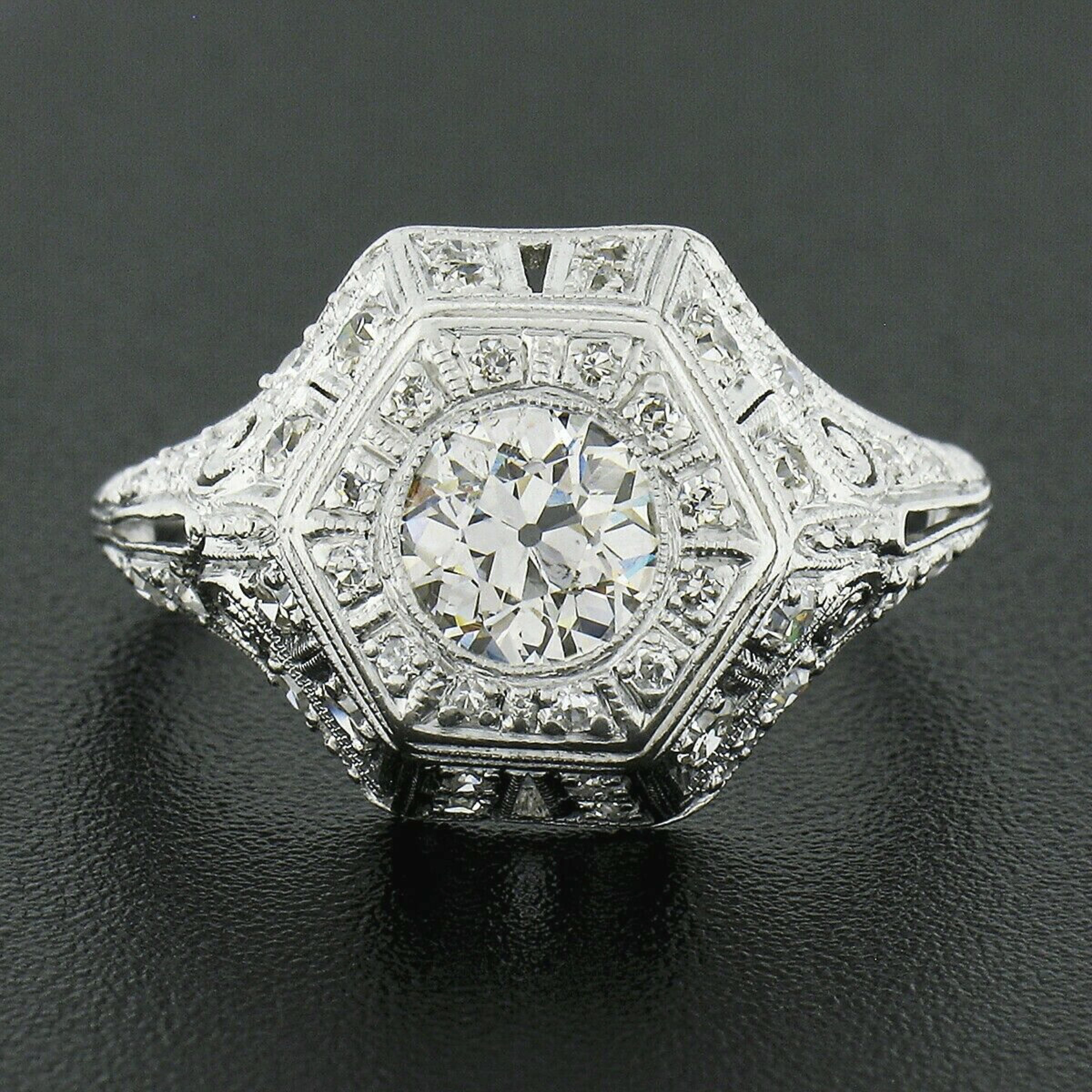 This is an absolutely breathtaking antique engagement or dinner ring that was crafted in solid platinum during the Edwardian era. This very unique and highly detailed ring features an approximately 0.80 carat, old European cut, diamond solitaire