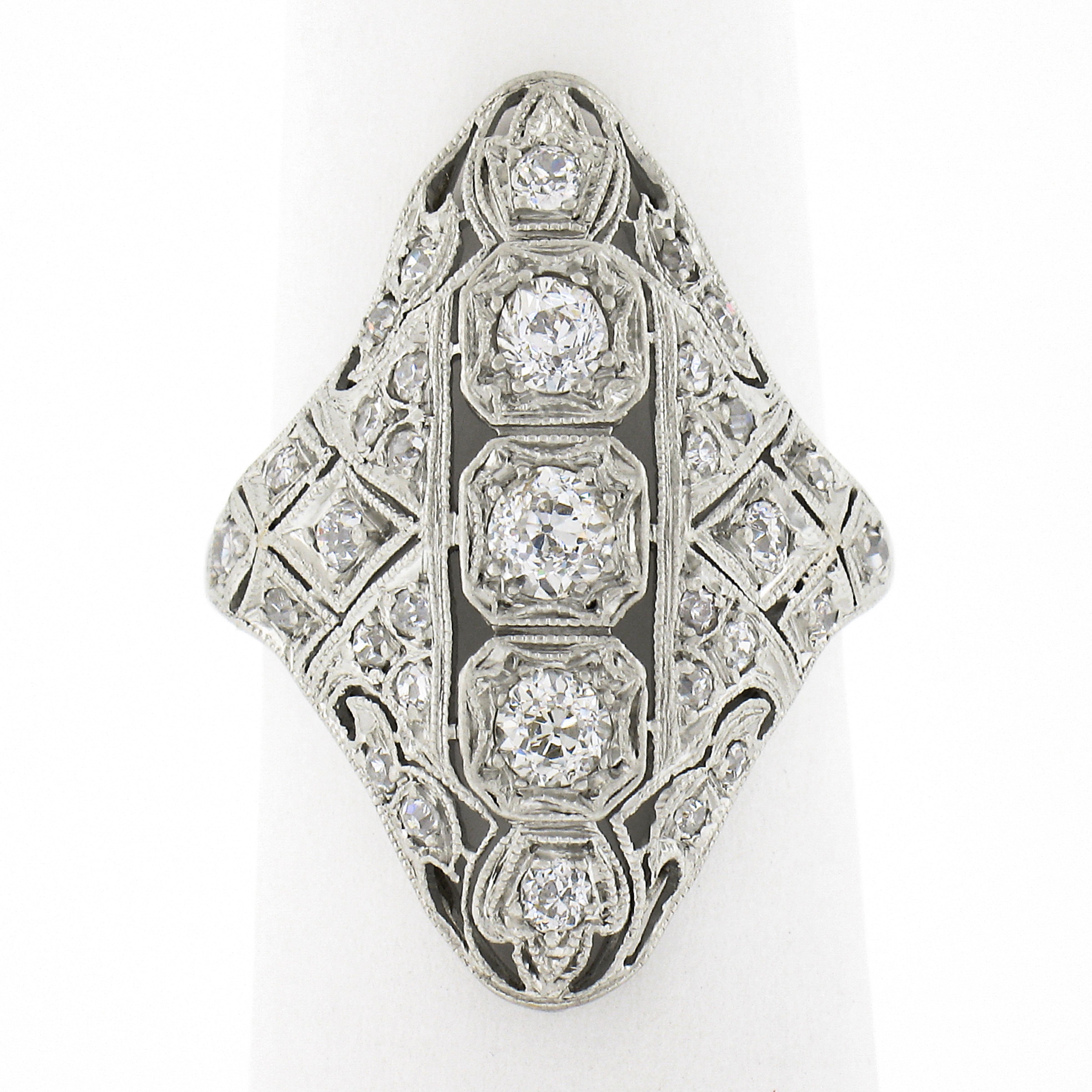 This incredible, all original, antique Edwardian period ring is crafted in solid platinum. The ring showcases 3 old European cut diamonds elegantly pave set in octagonal shaped settings across the center of the long and unusual design in which is