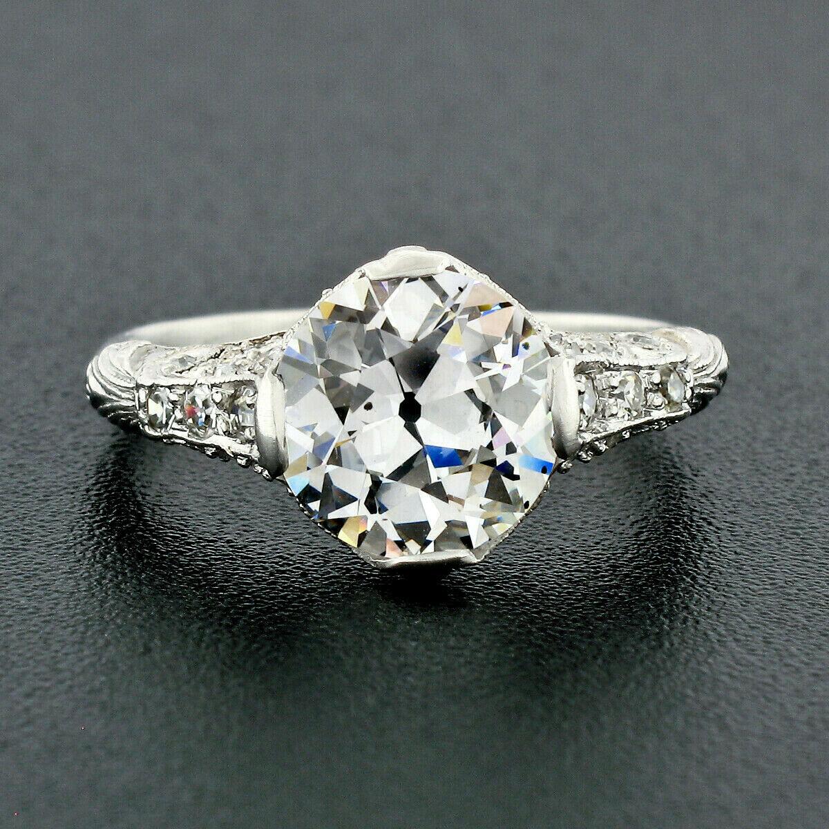 This breathtaking antique diamond engagement ring was crafted from solid platinum during the Edwardian period and features a gorgeous, old European cut diamond solitaire at its center. The diamond is GIA certified, it is 2.03 carats in weight and is