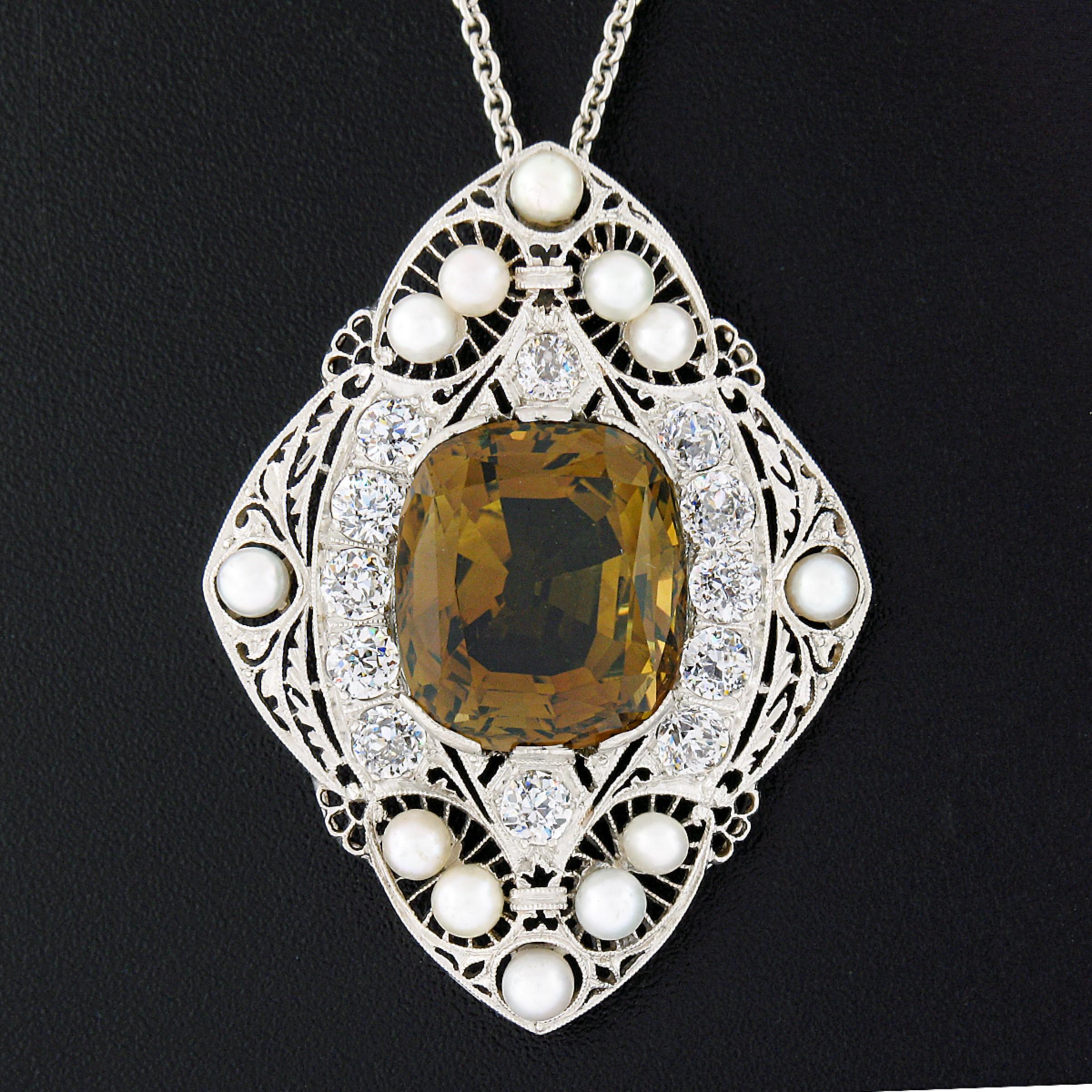 This breathtaking antique pendant was crafted in solid platinum during the Edwardian era and features a large and incredibly detailed design that carries fine quality stones throughout. It features a gorgeous, GIA certified, natural chrysoberyl