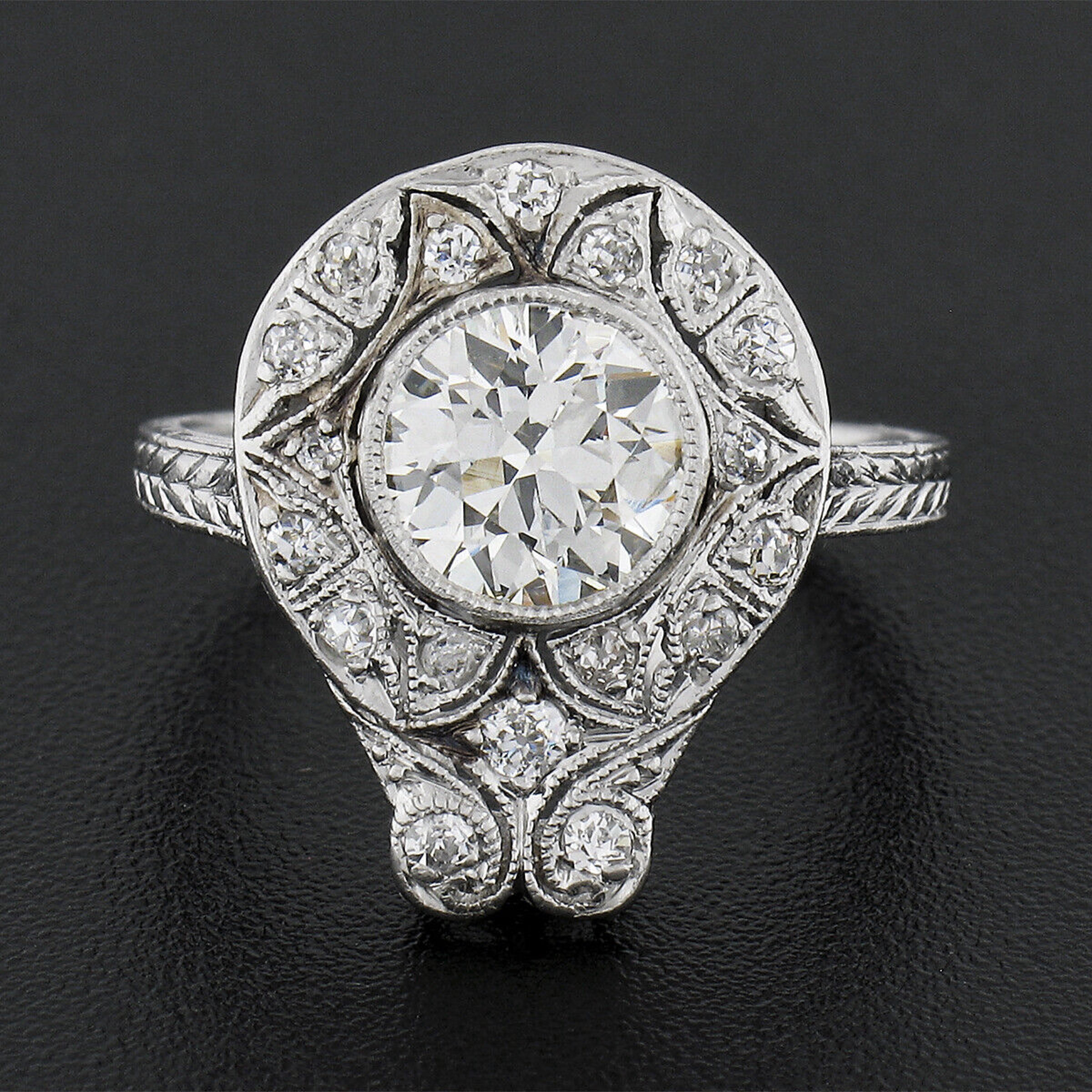 This is an absolutely breathtaking antique engagement or dinner ring that was very well crafted in solid platinum during the Edwardian era. This unique and highly detailed ring features an approximately 1.25 carat, old European cut, diamond