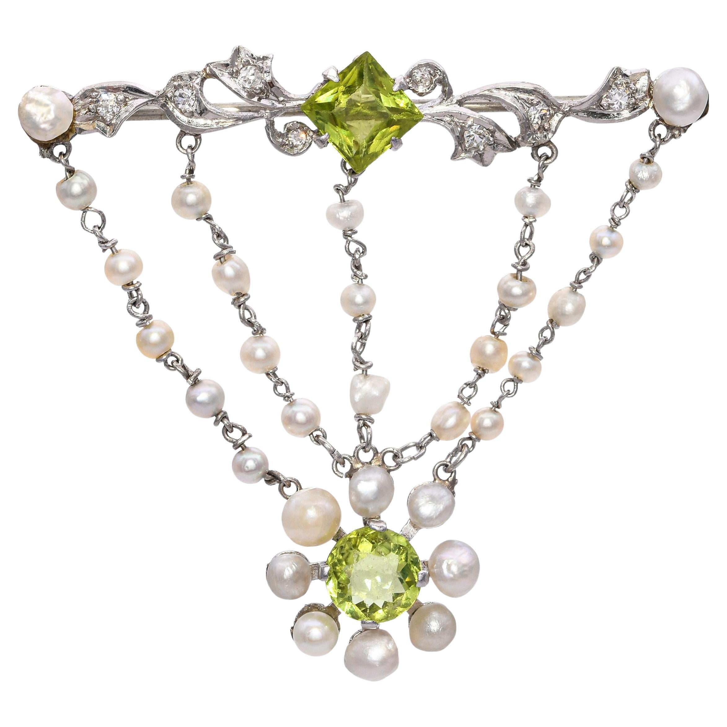 Antica spilla edoardiana in platino con peridoto e perla