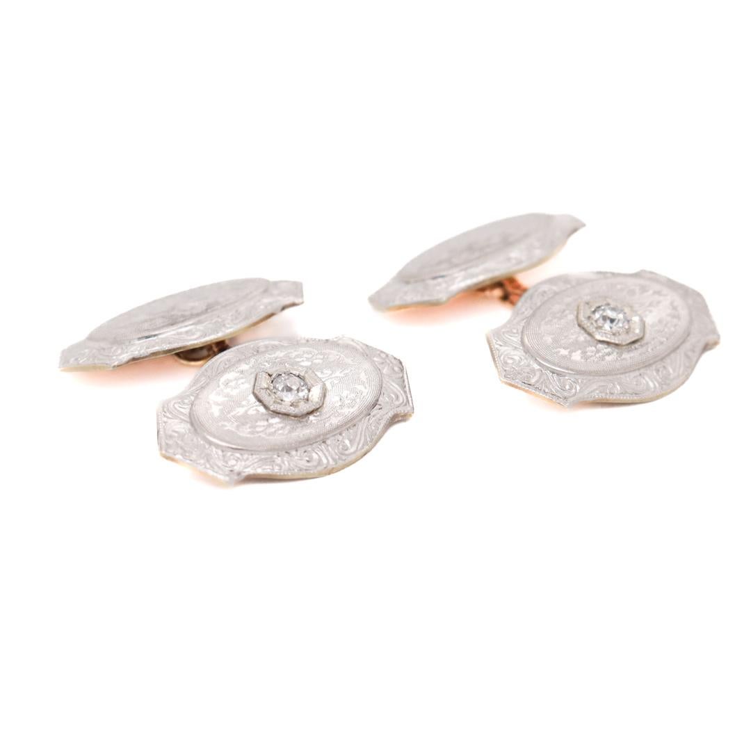 A fine pair of antique Edwardian cufflinks.

In platinum-topped 14k gold.

Each set with a round white Old European cut diamond and decorated throughout with engraved & etched engine turned decoration.

Marked to each link 'PL on 14k'.

Simply a