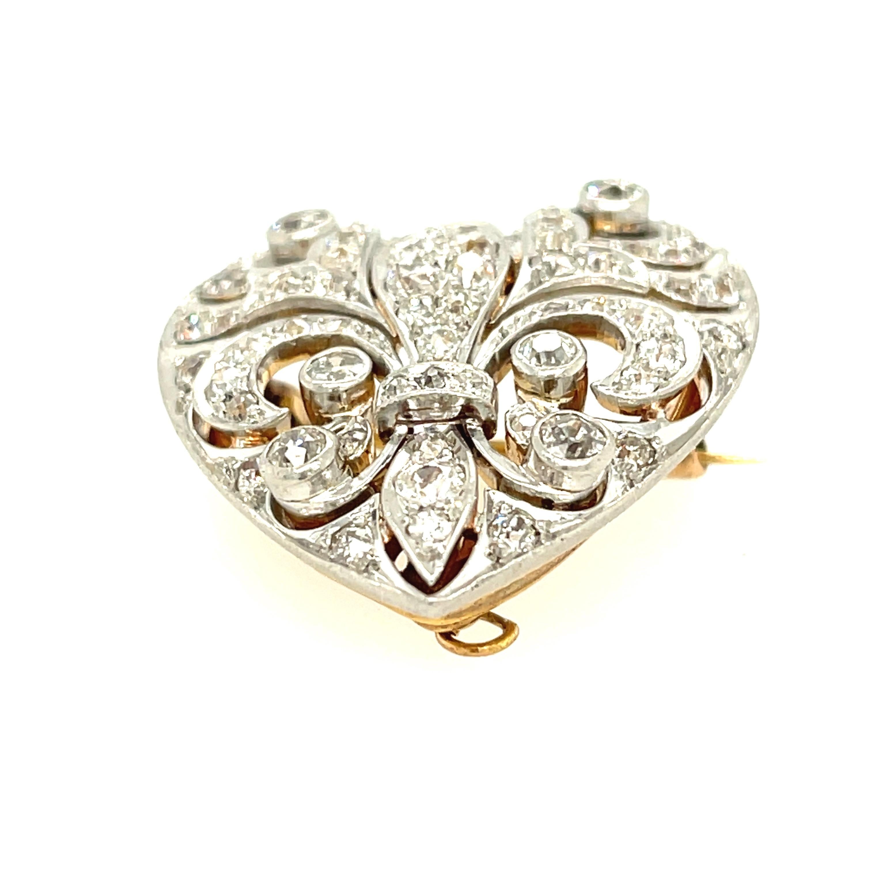 A pretty antique Edwardian platinum topped gold diamond heart brooch, circa 1910. The brooch is removable and there is a bale that can be lifted to wear the heart as a pendant. The heart has diamonds set in the shape of a fleur di lys. The unique