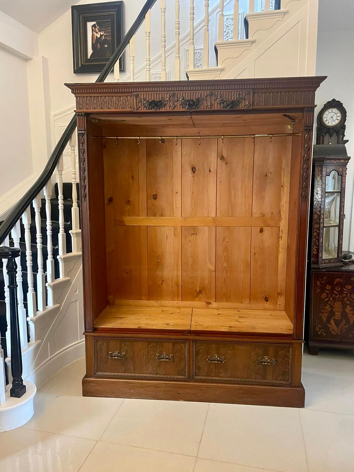 Antique Edwardian quality carved mahogany wardrobe having a quality carved mahogany cornice above a pair of bevelled edge carved mahogany framed doors opening to reveal a large hanging compartment with the original brass rail and hooks above two