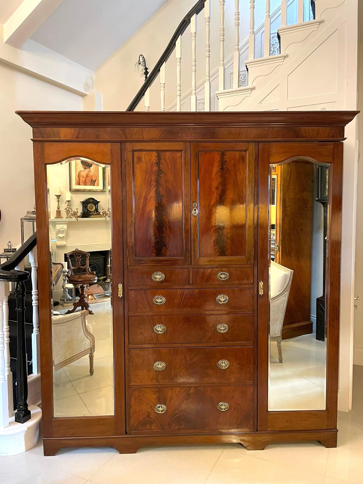Antique Edwardian quality figured mahogany wardrobe having a shaped cornice and a figured mahogany frieze above a pair of figured mahogany cupboard doors opening to reveal two shelves above two short and four long figured mahogany cockbeeded drawers
