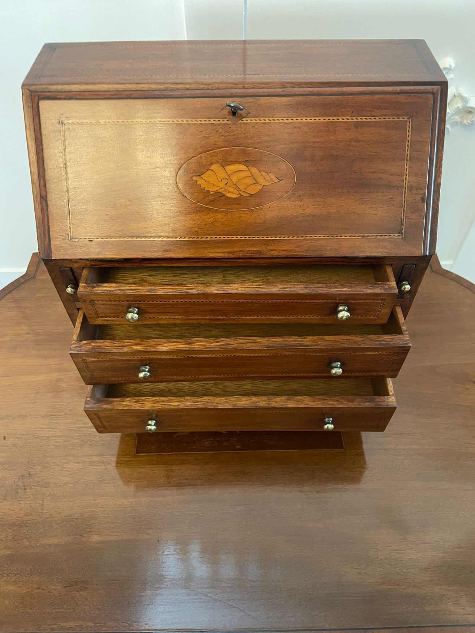 Antique Edwardian quality mahogany inlaid miniature bureau having a quality mahogany inlaid fall opening to reveal a fitted interior above three mahogany inlaid drawers with original brass handles and standing on bracket feet 

Measures: H 30 x W