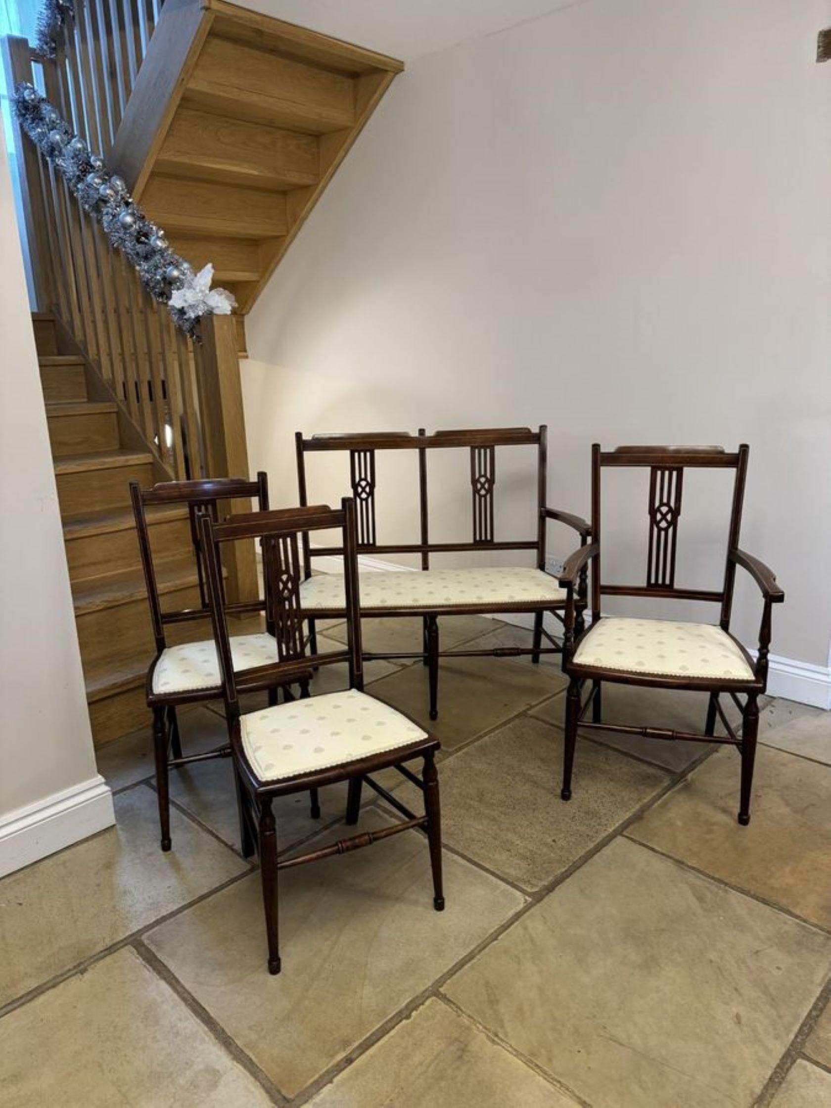 Antique Edwardian quality mahogany inlaid three piece suite, consisting of a quality mahogany inlaid settee, arm chair and a pair of side chairs with open arms, turned tapering front legs and outswept back legs united by elegant turned stretchers.