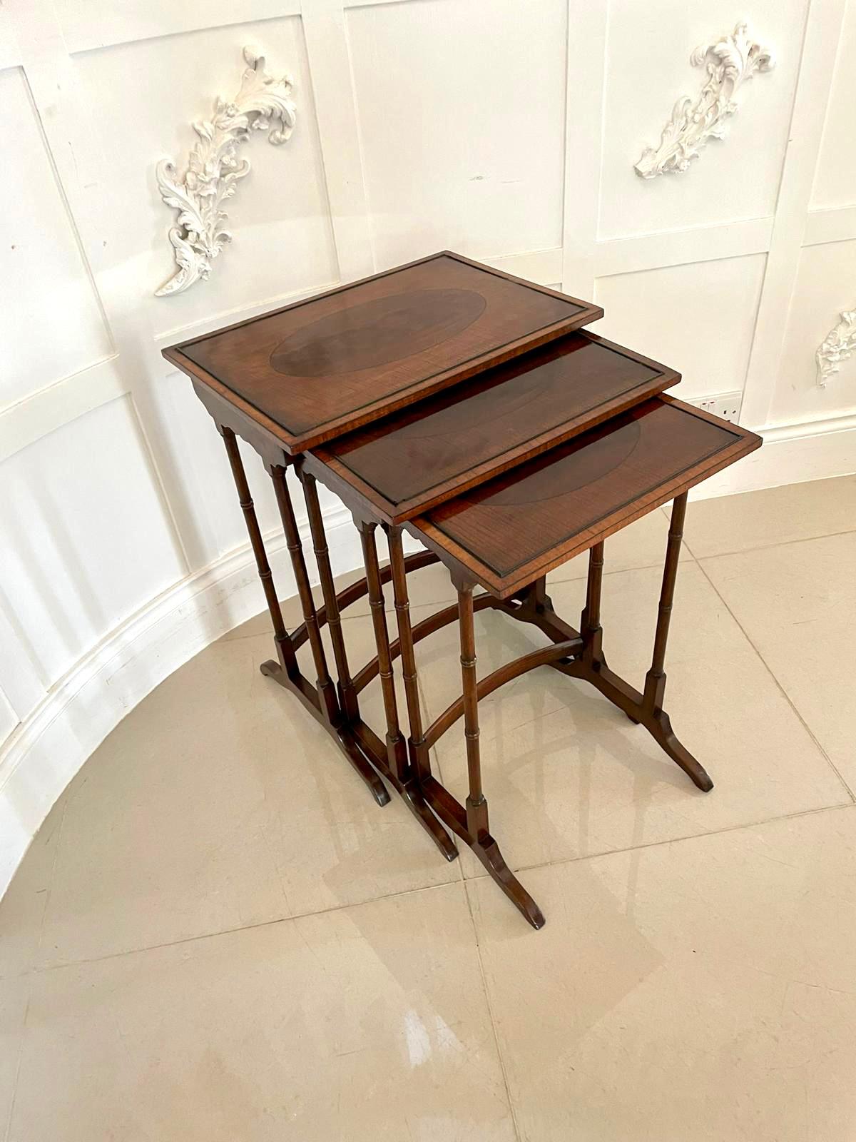 Antique Edwardian quality mahogany nest of 3 tables having quality fiddleback mahogany crossbanded tops with figured mahogany oval inlaid centres supported by fine turned mahogany columns and raised on shaped feet united by shaped stretchers
