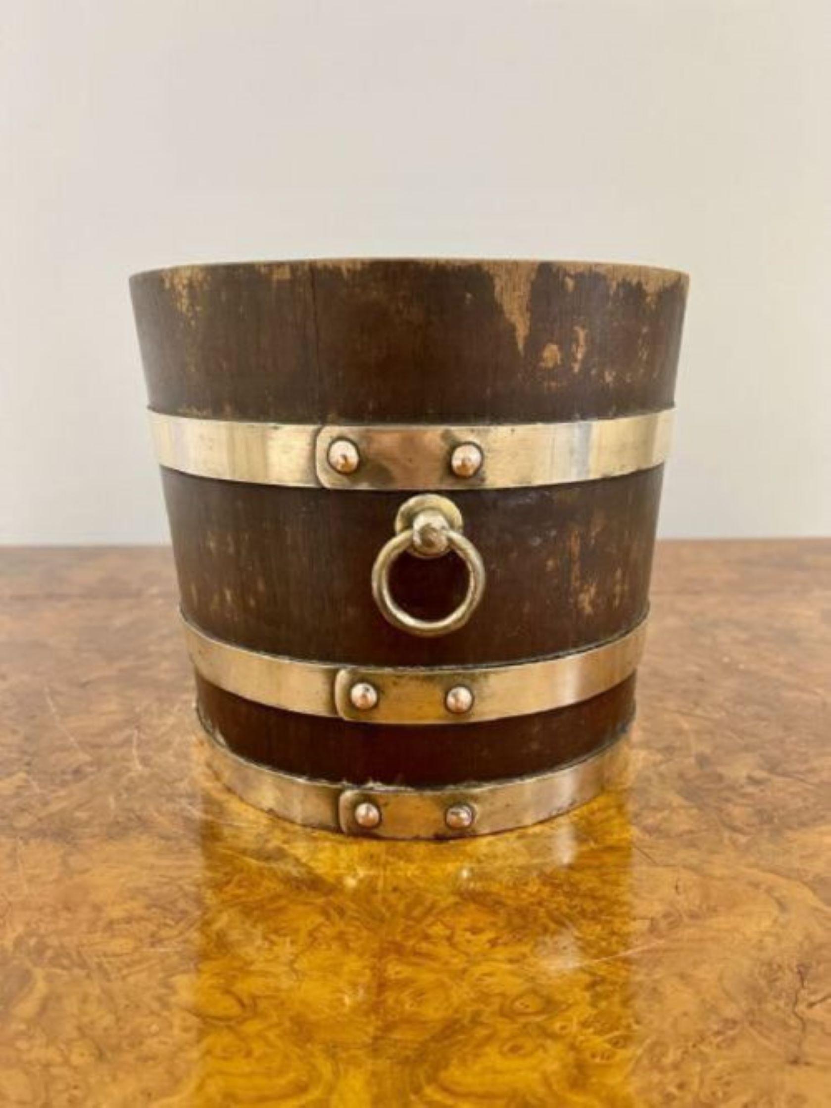 Antique Edwardian quality oak brass bounded jardiniere having a quality circular oak jardiniere with original brass bounds and brass carrying handles 