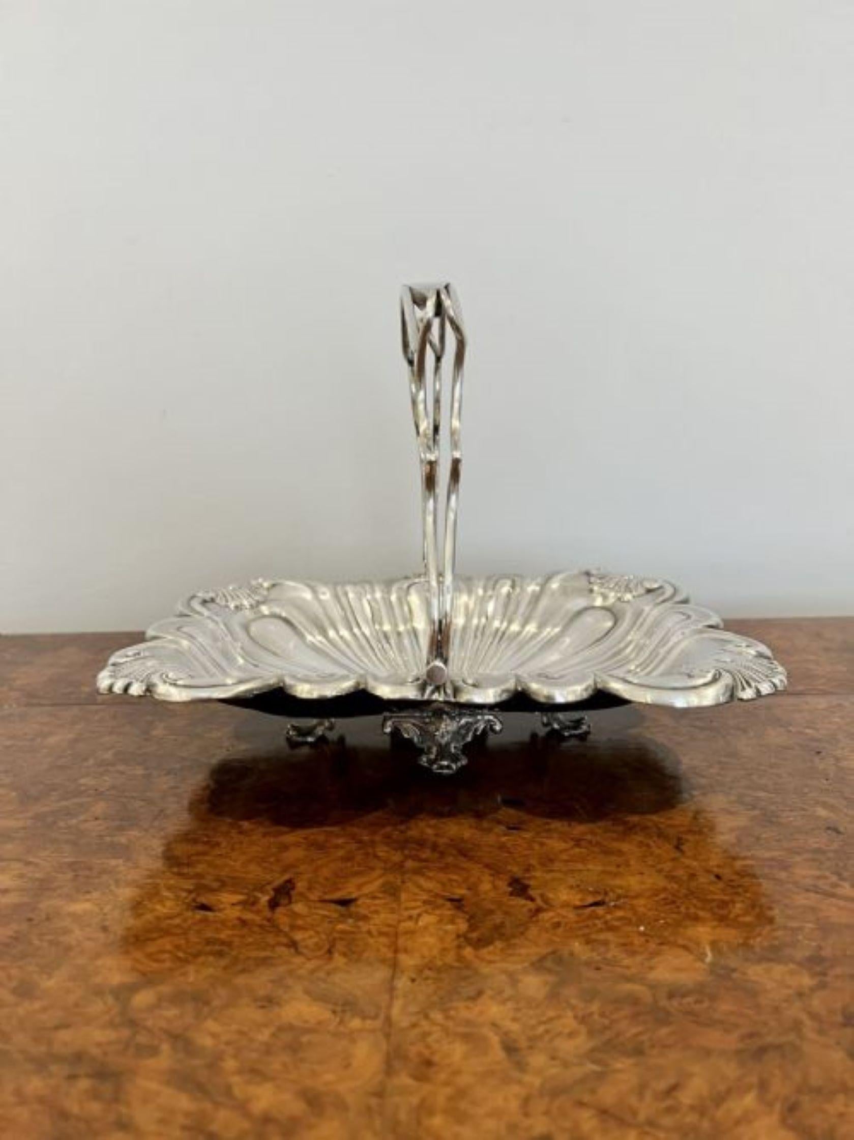 Antique Edwardian quality silver plated ornate cake basket having a quality shaped swing handle above a silver plated shaped wavy edge basket standing on four ornate feet