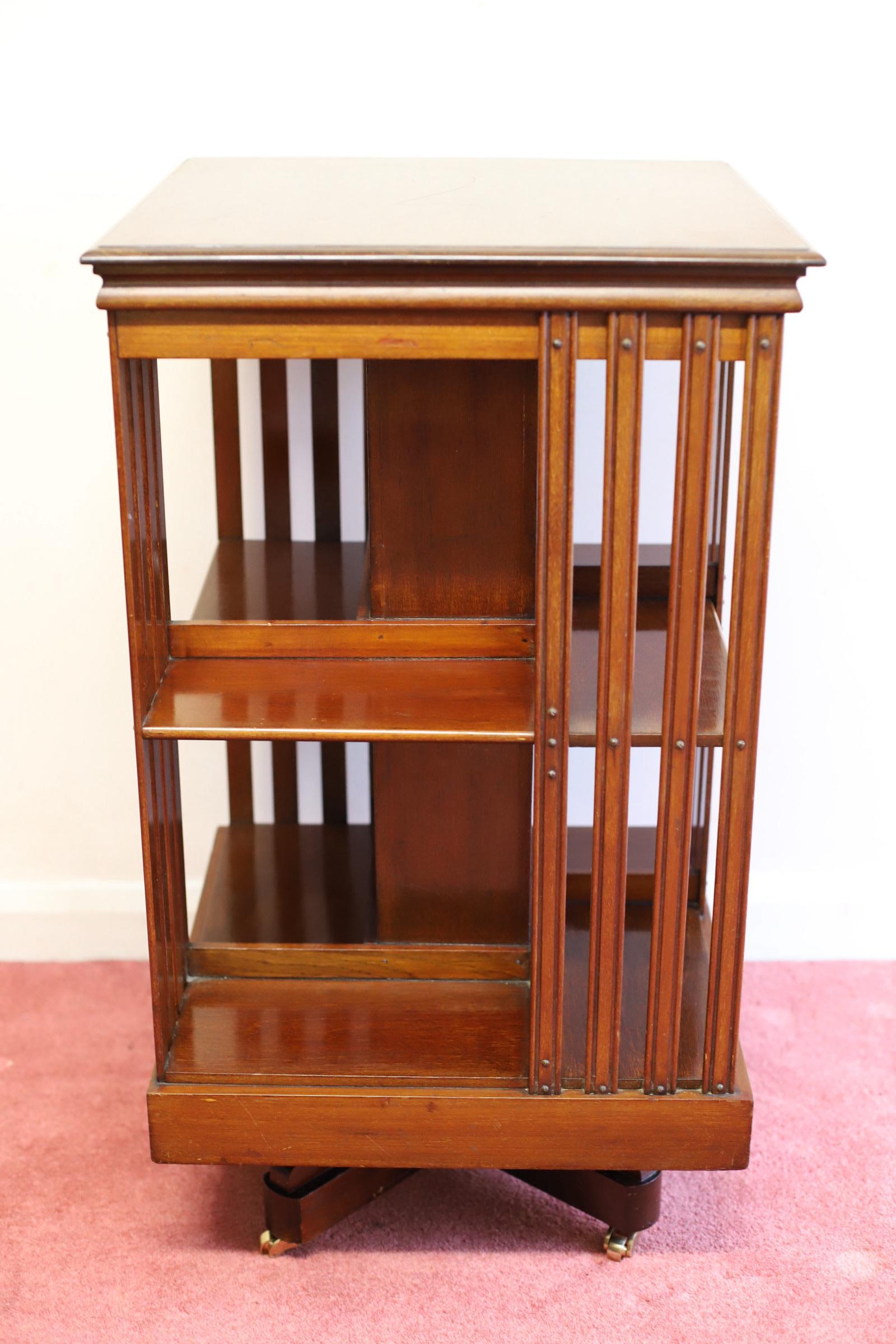 This lovely antique bookcase is a charming addition to any antique furniture collection. Crafted from beautiful mahogany wood, this two-shelved bookcase is designed to revolve, making it both practical and aesthetically pleasing. Its petite size,