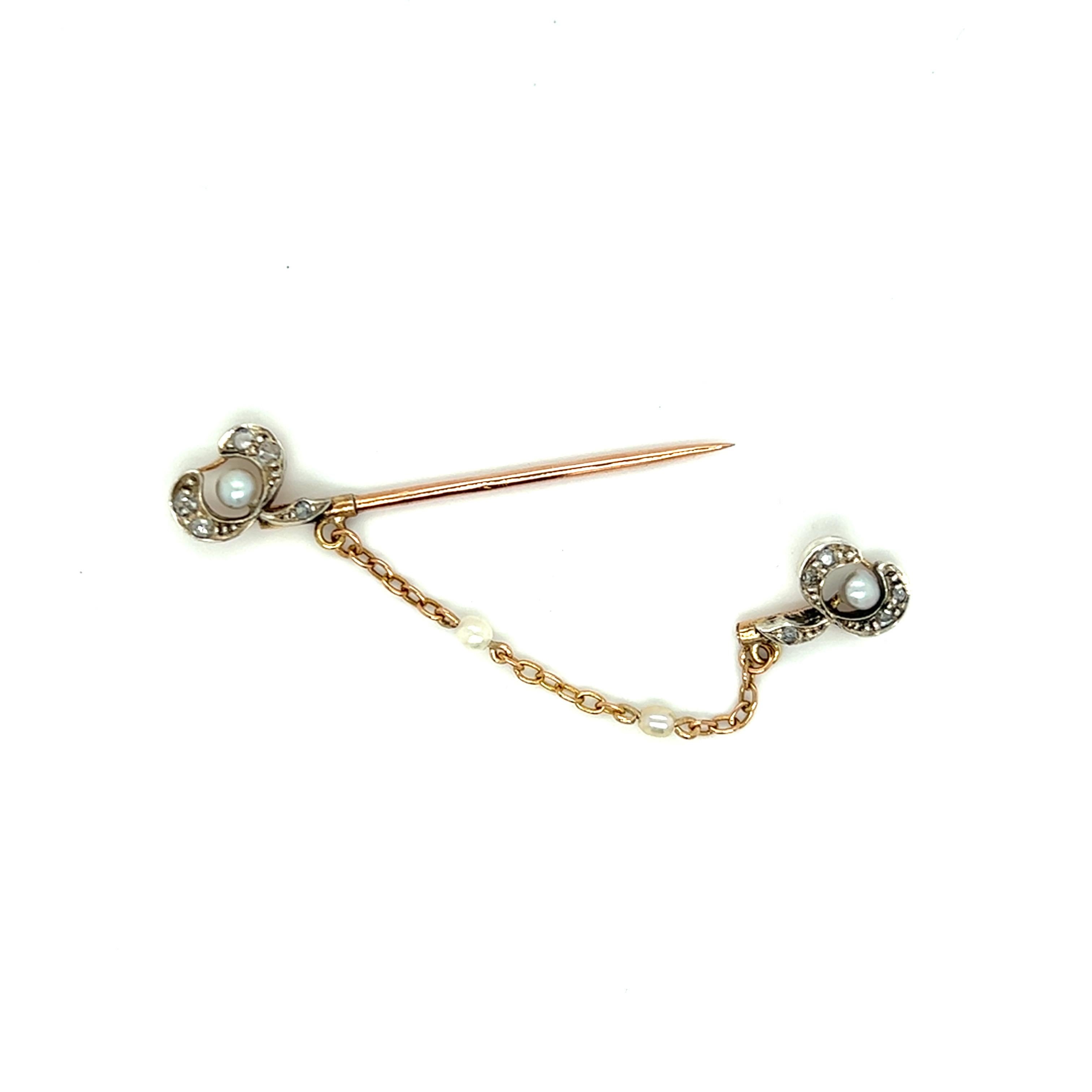 The Estate Antique Seed Pearl and Diamond Pin is from the Edwardian era and is crafted from sterling silver and 9 karat yellow gold. It features 4 seed pearls and 10 rose-cut diamonds weighing 0.10 carat total weight. The pin measures approximately