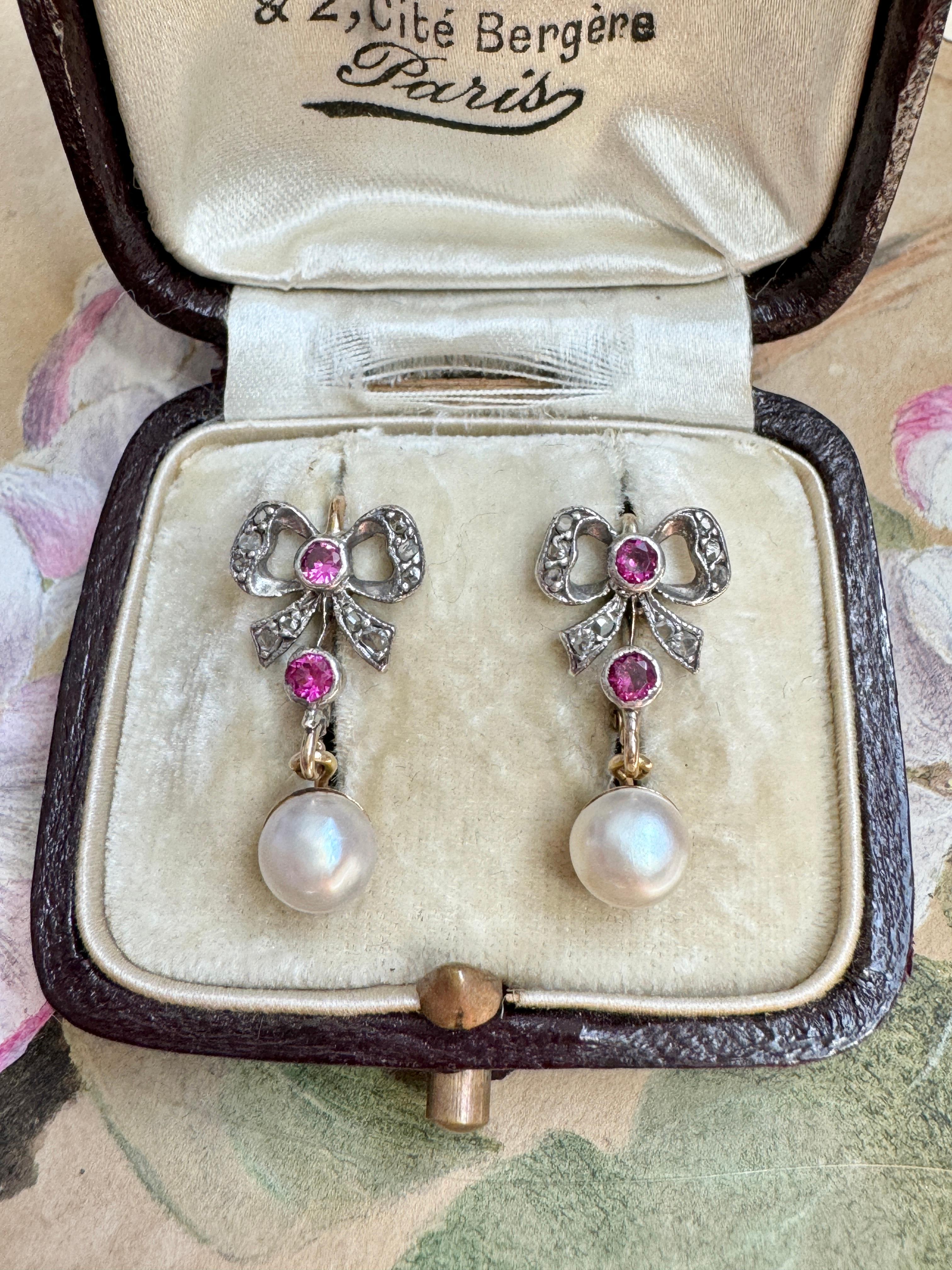 Diese süßen edwardianischen Ohrringe bestehen aus fließenden, mit Diamanten im Rosenschliff besetzten Bändern, die mit leuchtenden synthetischen Rubinen akzentuiert sind und an denen glänzende Perlen hängen. Gefertigt in Silber mit