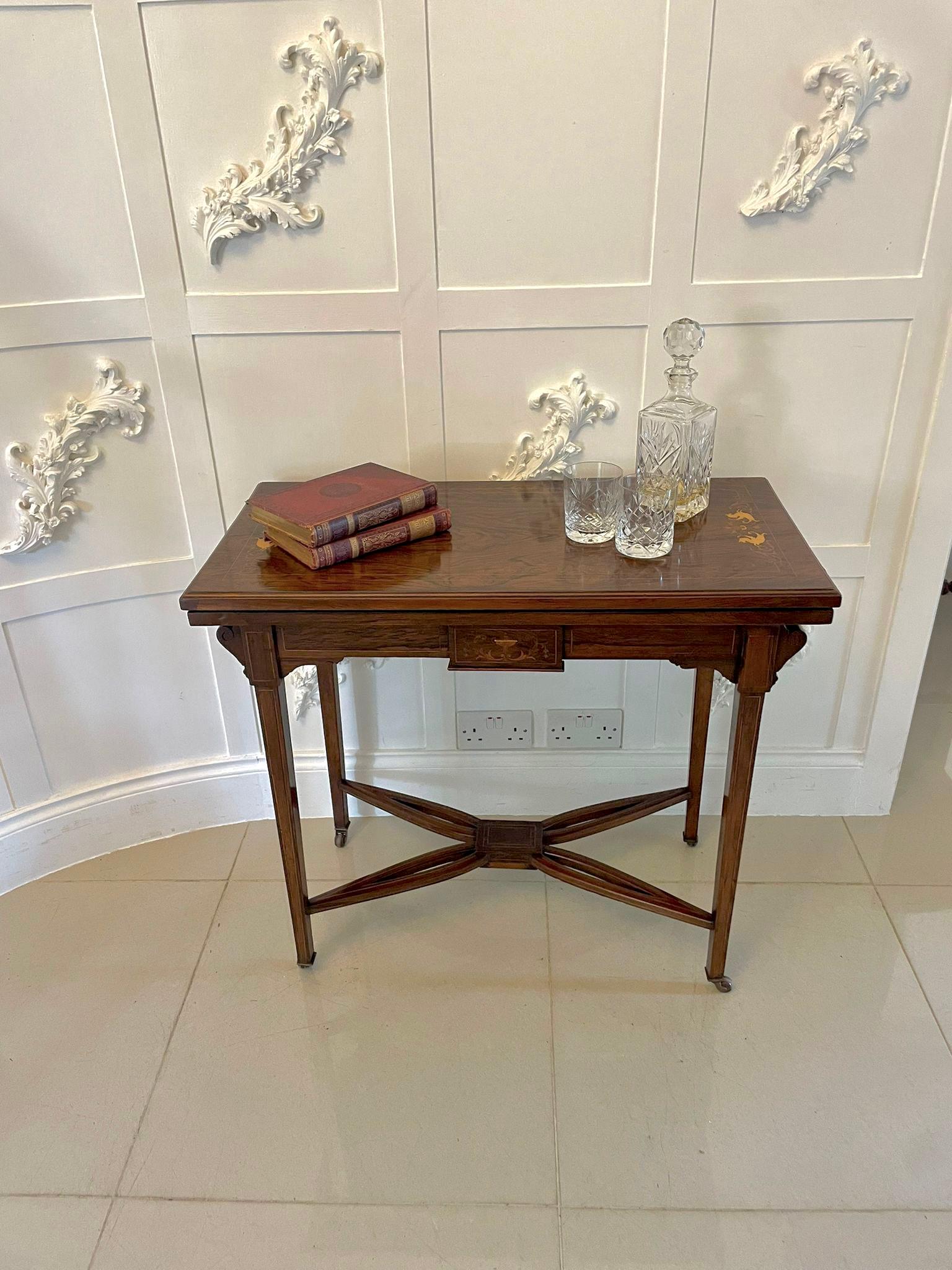 Antique Edwardian rosewood inlaid freestanding card table having a very attractive ivorine and satinwood inlay. The top swivels to reveal a green baize interior and it boasts a pretty inlaid frieze supported by four square inlaid tapering legs with