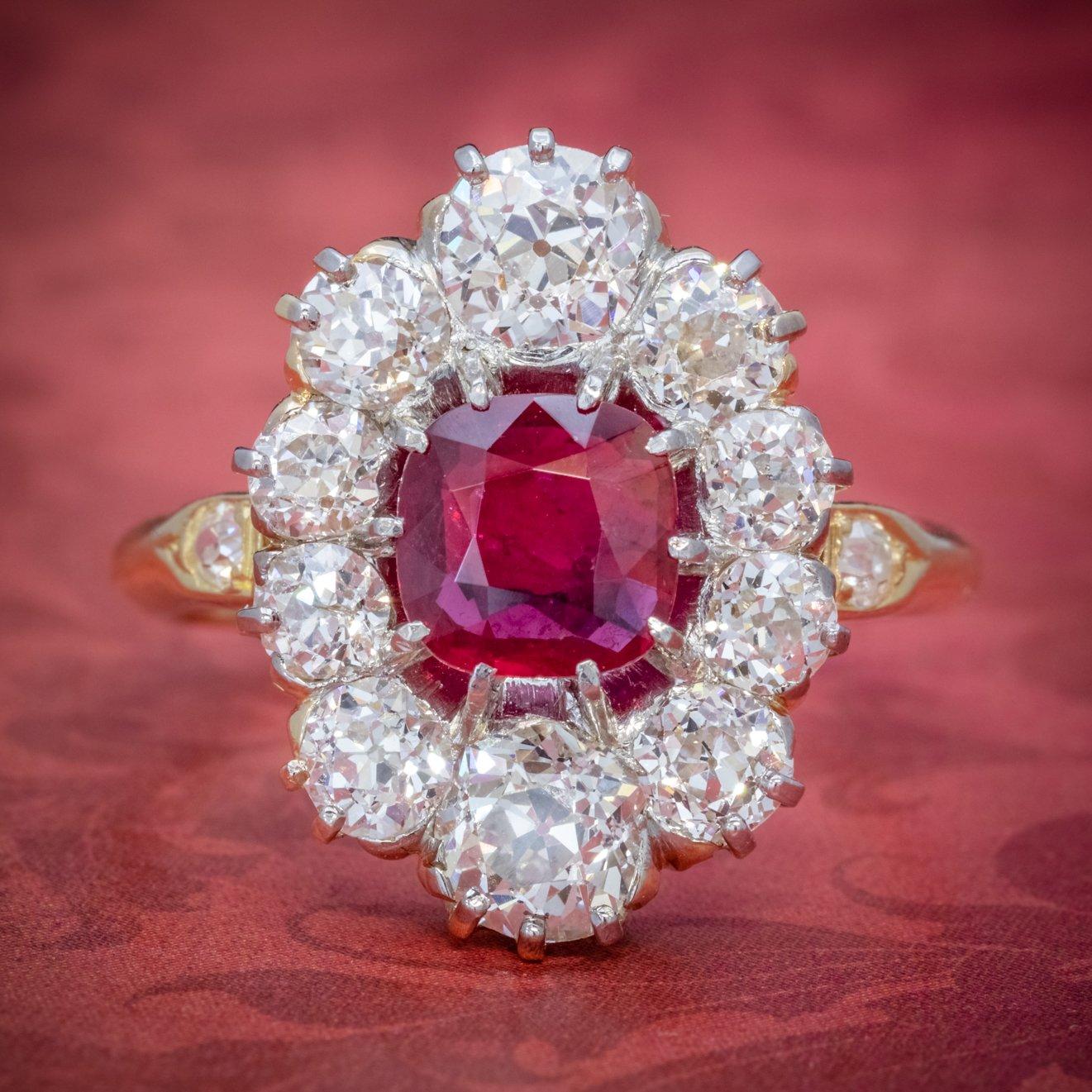 A spectacular antique Edwardian cluster ring from the early 1900s adorned with a cherry-pink cushion cut ruby at its heart complete with two gem certifications that verify the stone is natural and weighs an estimated 1.15ct with a spread of approx.