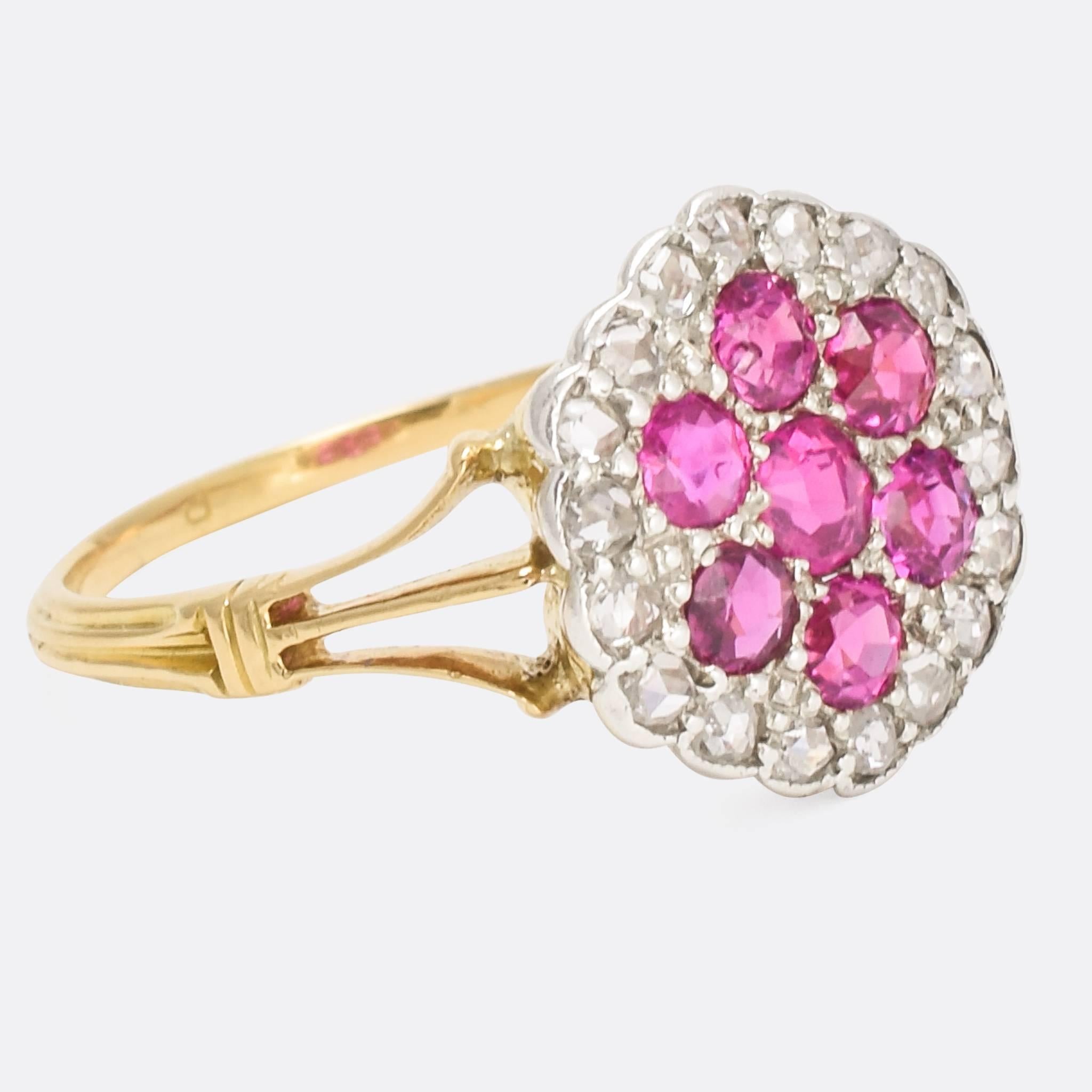 A sublime antique pavé cluster ring, the platinum head modelled as a stylised flower. It's set with seven bright rubies, within a cluster of 18 rose cut diamonds. With pretty trifurcated split shoulders and a grooved band, it's a very beautiful