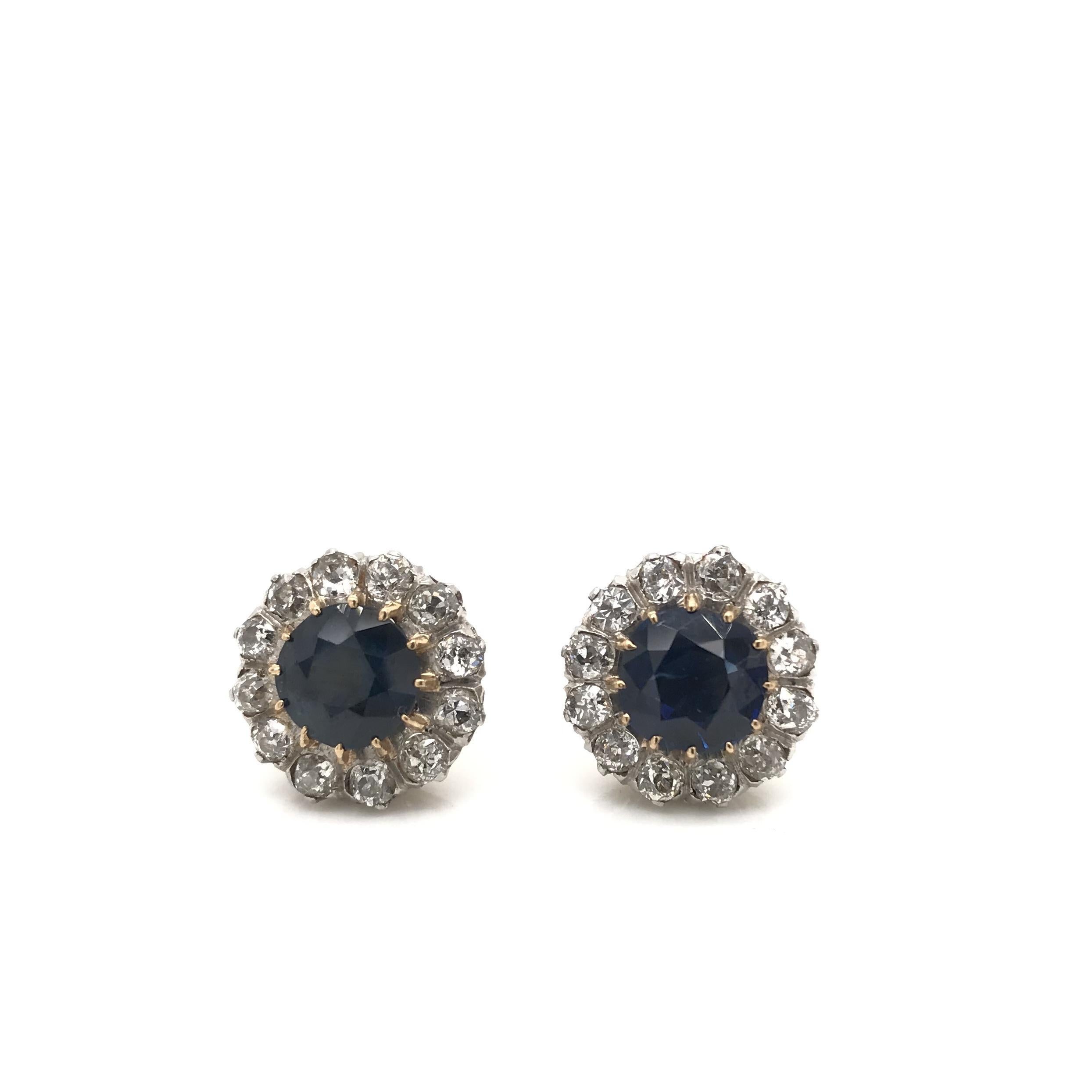 These dazzling antique earrings were crafted sometime during the Edwardian design period (1900-1920). Each earring features a stunning cushion cut blue sapphire. The sapphires have been certified by the Gemological Institute of America (GIA) and