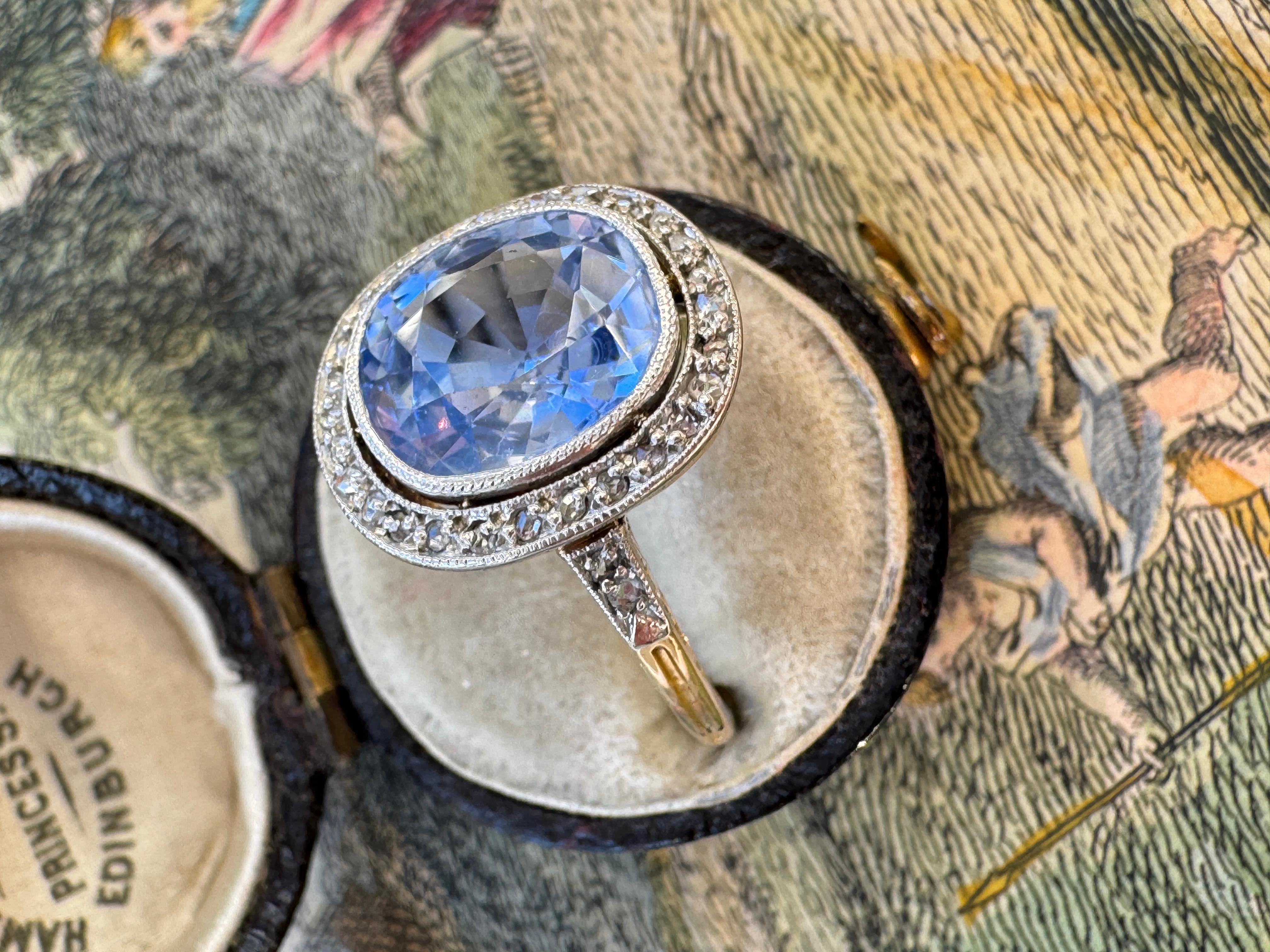 Dieser exquisite Ring aus dem frühen 20. Jahrhundert präsentiert einen leuchtend kornblumenblauen Ceylon-Saphir im Kissenschliff, der von GIA als natürlich und unerhitzt zertifiziert wurde. Der von Hand aus Platin und 18-karätigem Gold gefertigte