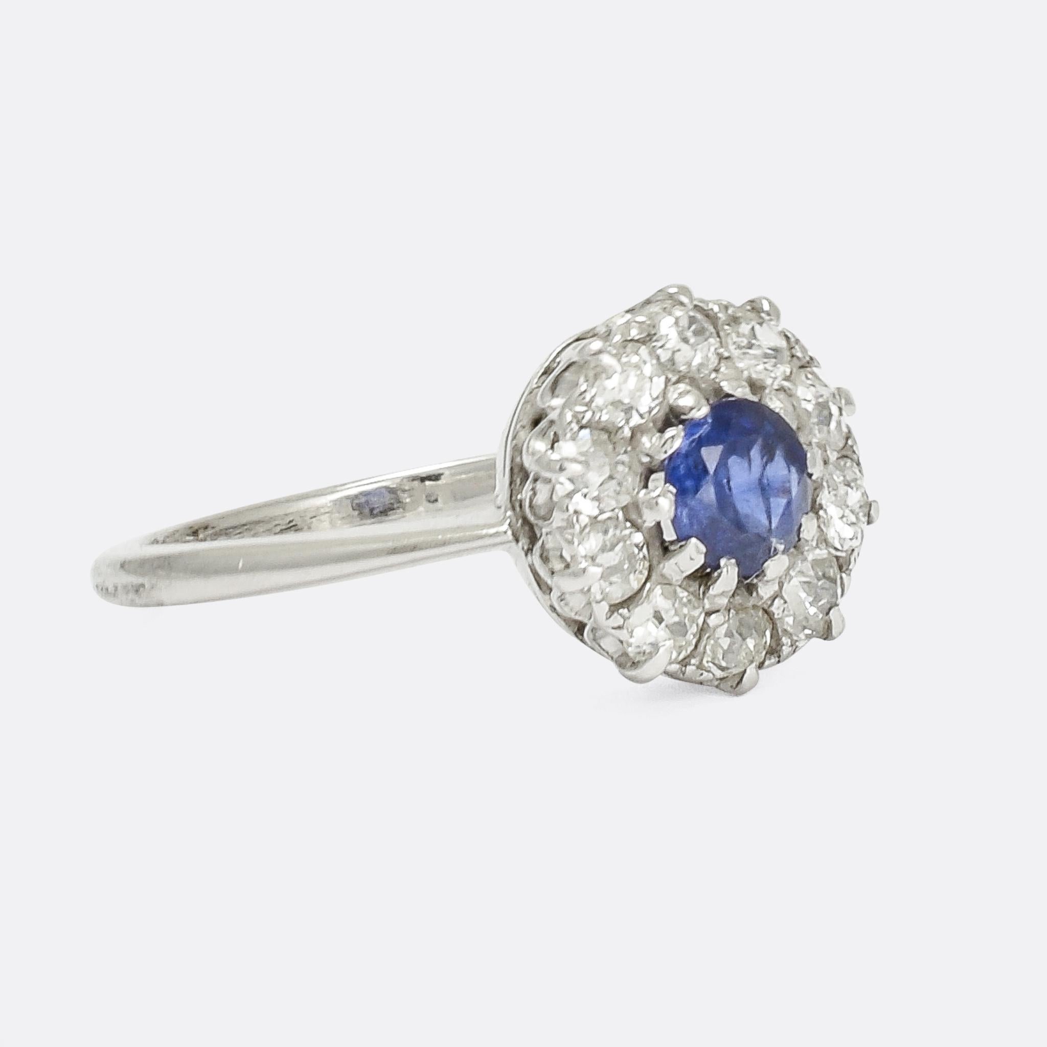 A pretty Edwardian round cluster ring set with a bright central blue sapphire within a halo of old cut diamonds. It dates from the early 20th Century, made around 1910, in 14k white gold with platinum claw settings.

STONES 
Natural Sapphire -