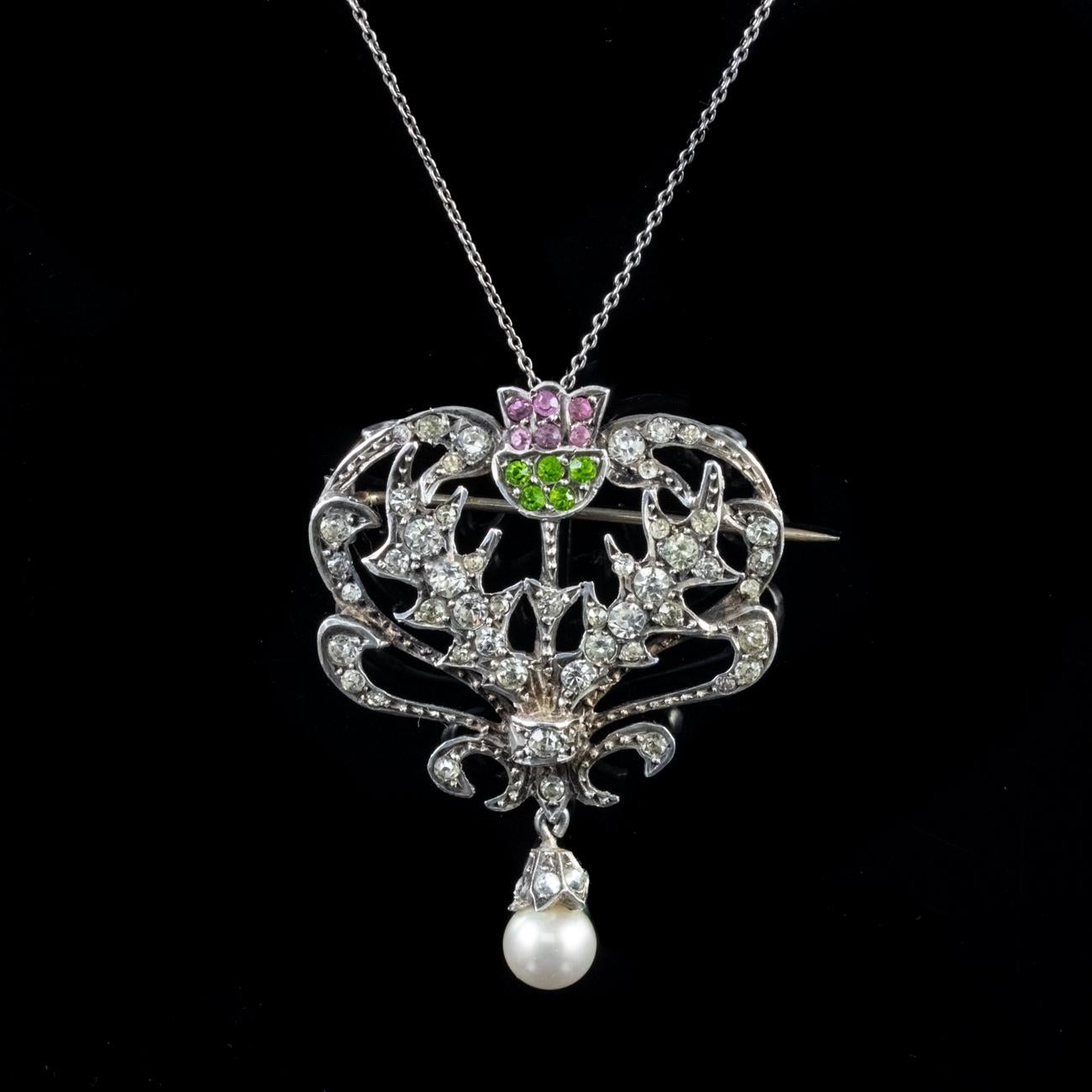 This stunning Antique Edwardian Scottish Suffragette necklace and pendant has been commissioned in Sterling Silver. The pendant features a Scottish thistle shaped design and has been set with an array of Paste stones which are coloured green, white