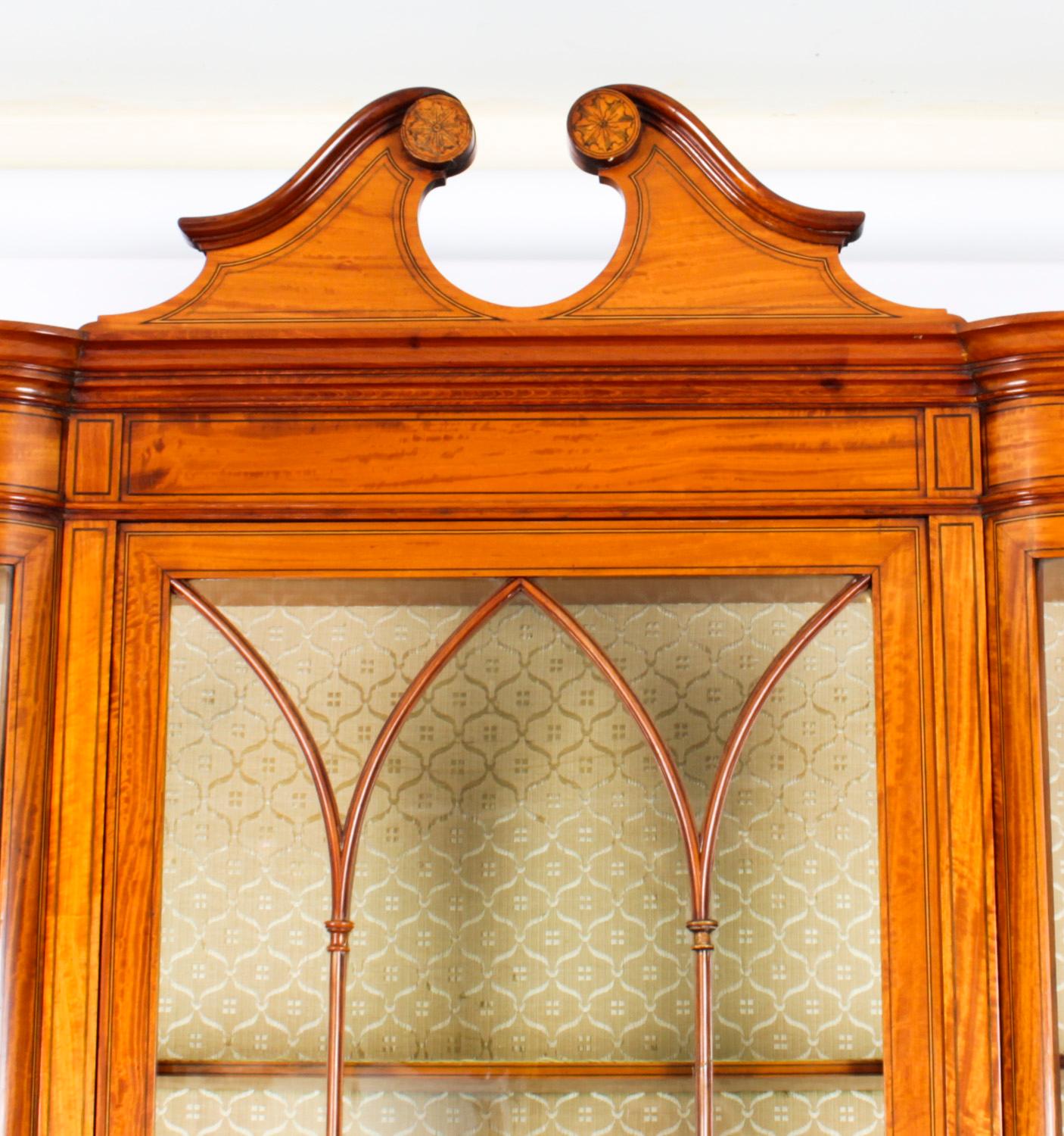 A stunning antique English Edwardian satinwood serpentine display cabinet, Circa 1890 in date,

The top part is surmounted with a stunning broken pediment cornice and has a large central door with astragal glazing flanked by shaped serpentine